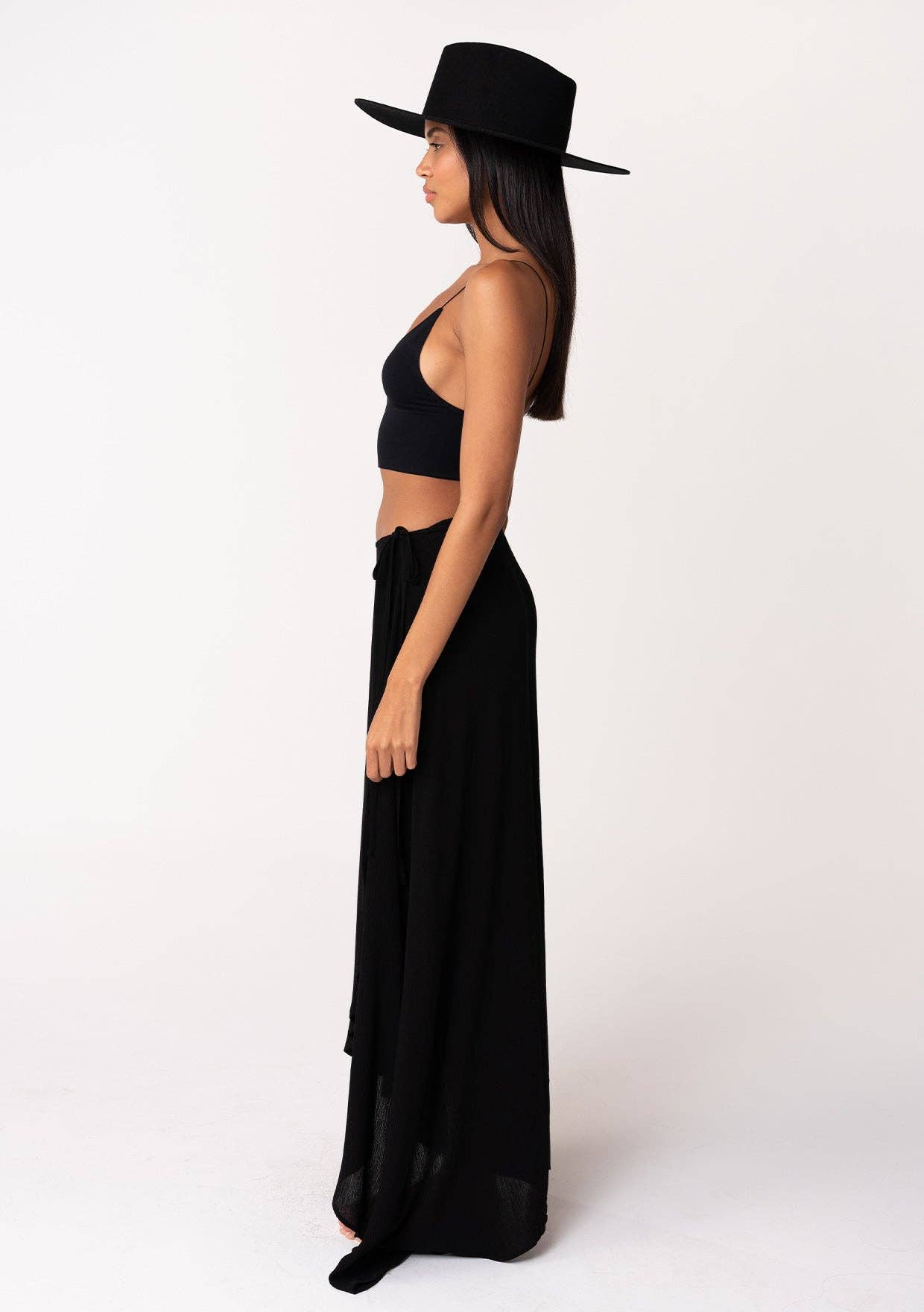 Woman wearing a black hat and Summer Solid Wrap Maxi Skirt, styled with a black crop top against a white background