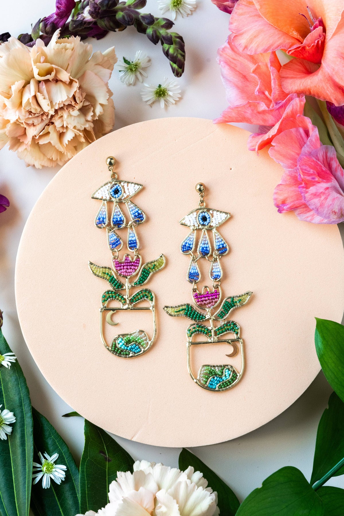 Cycle of Consciousness colorful beaded floral statement earrings on a botanical display