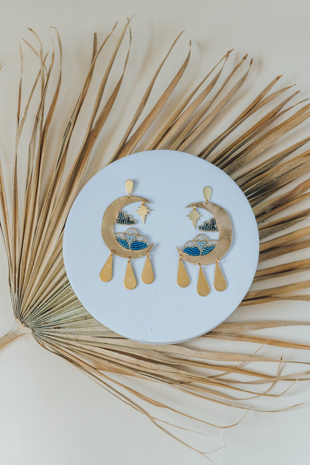 Moonscape Earrings gold celestial drop earrings with moon and star details on a round display card