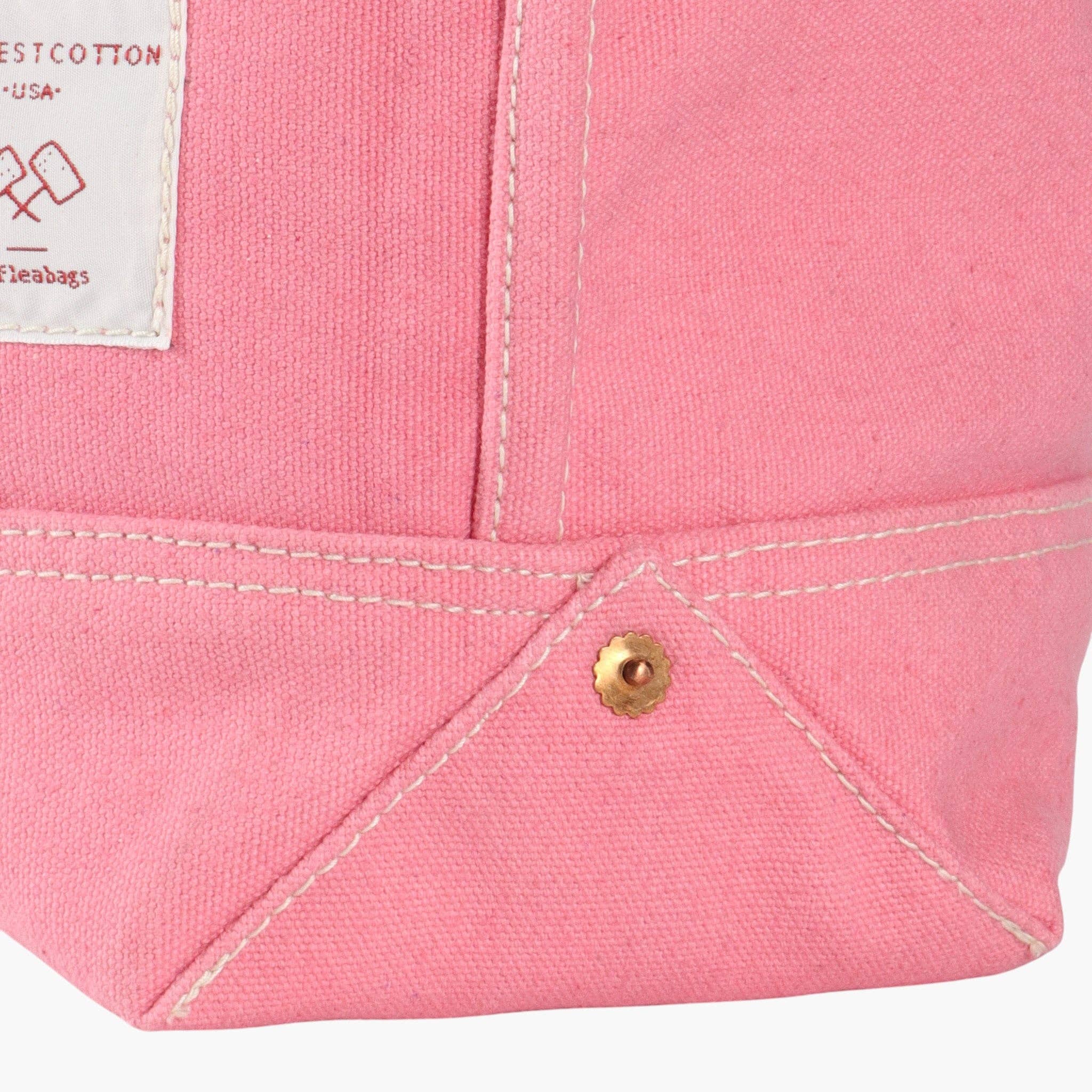 Close-up of the bottom corner and stitching detail of a Small East West Tote | Flamingo in pink canvas fabric