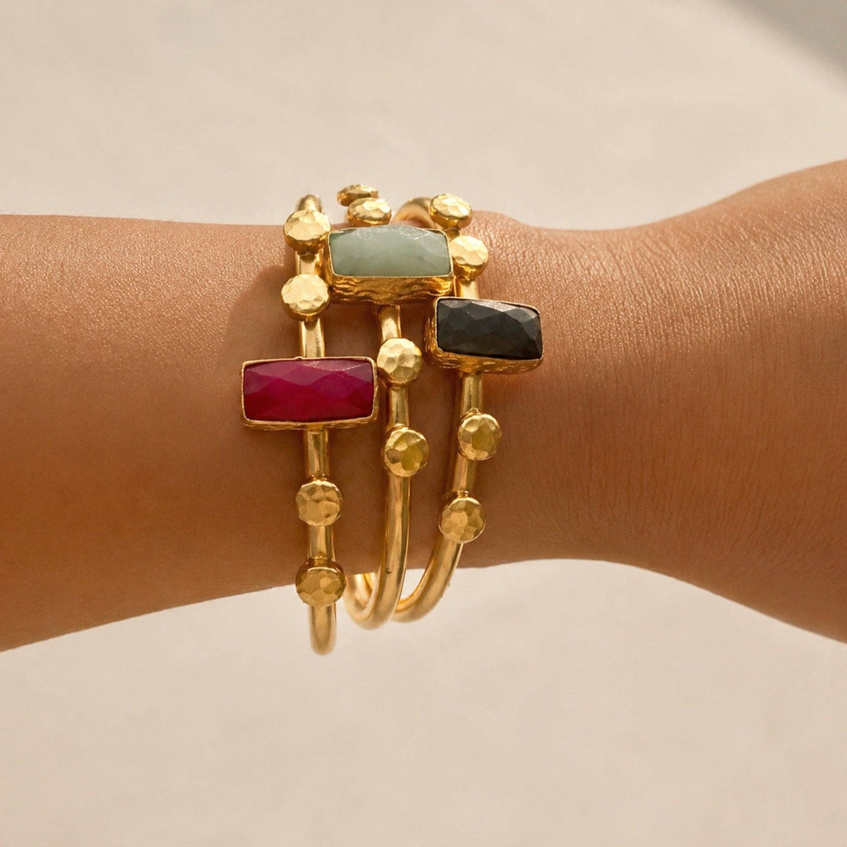 Harem Lapis Lazuli Bangle with gold tone details and colorful gemstone accents on a wrist