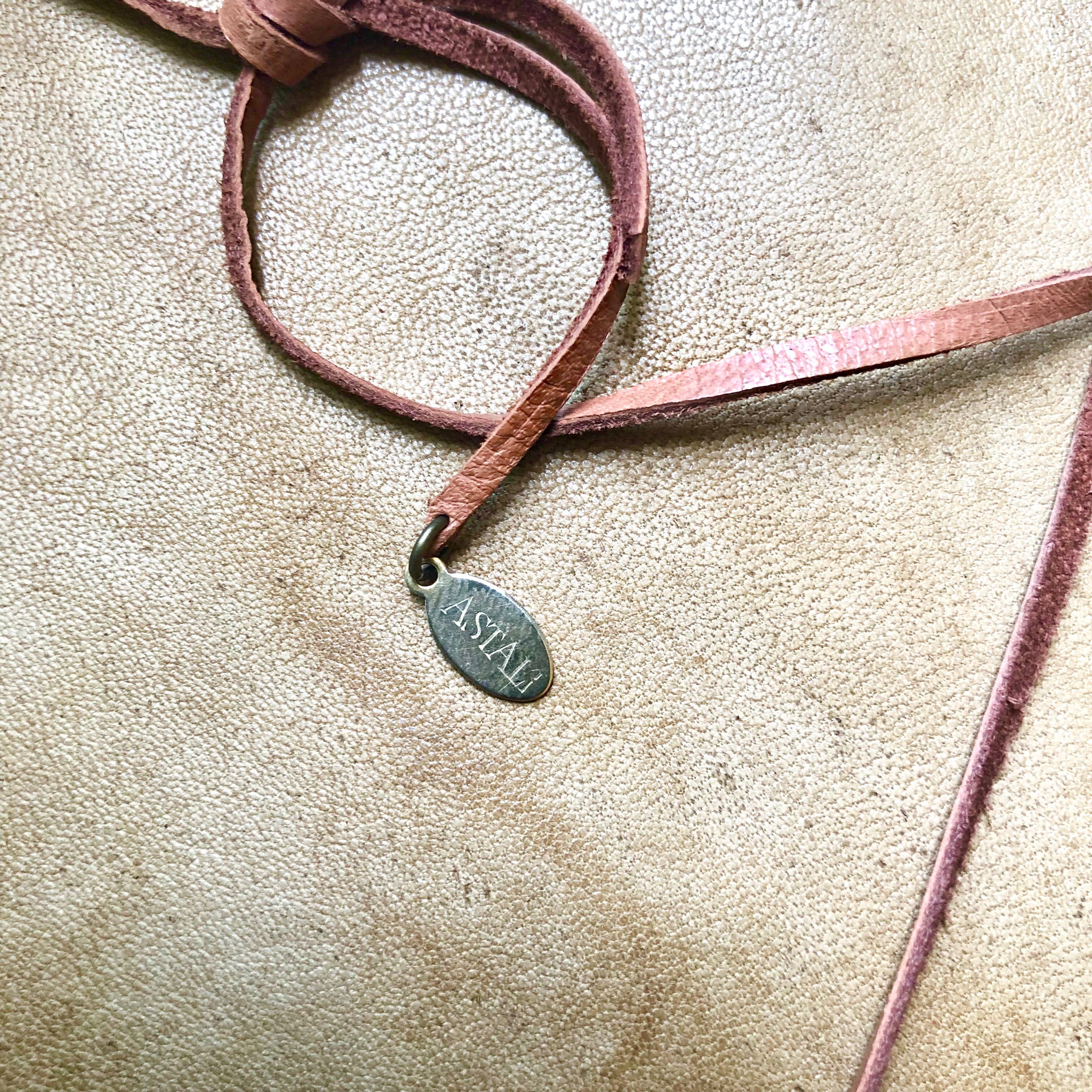 Coyote Tooth & Blue Opal Necklace, Wheat Penny, Rust Leather with soft rust leather strap and small metal tag on textured background
