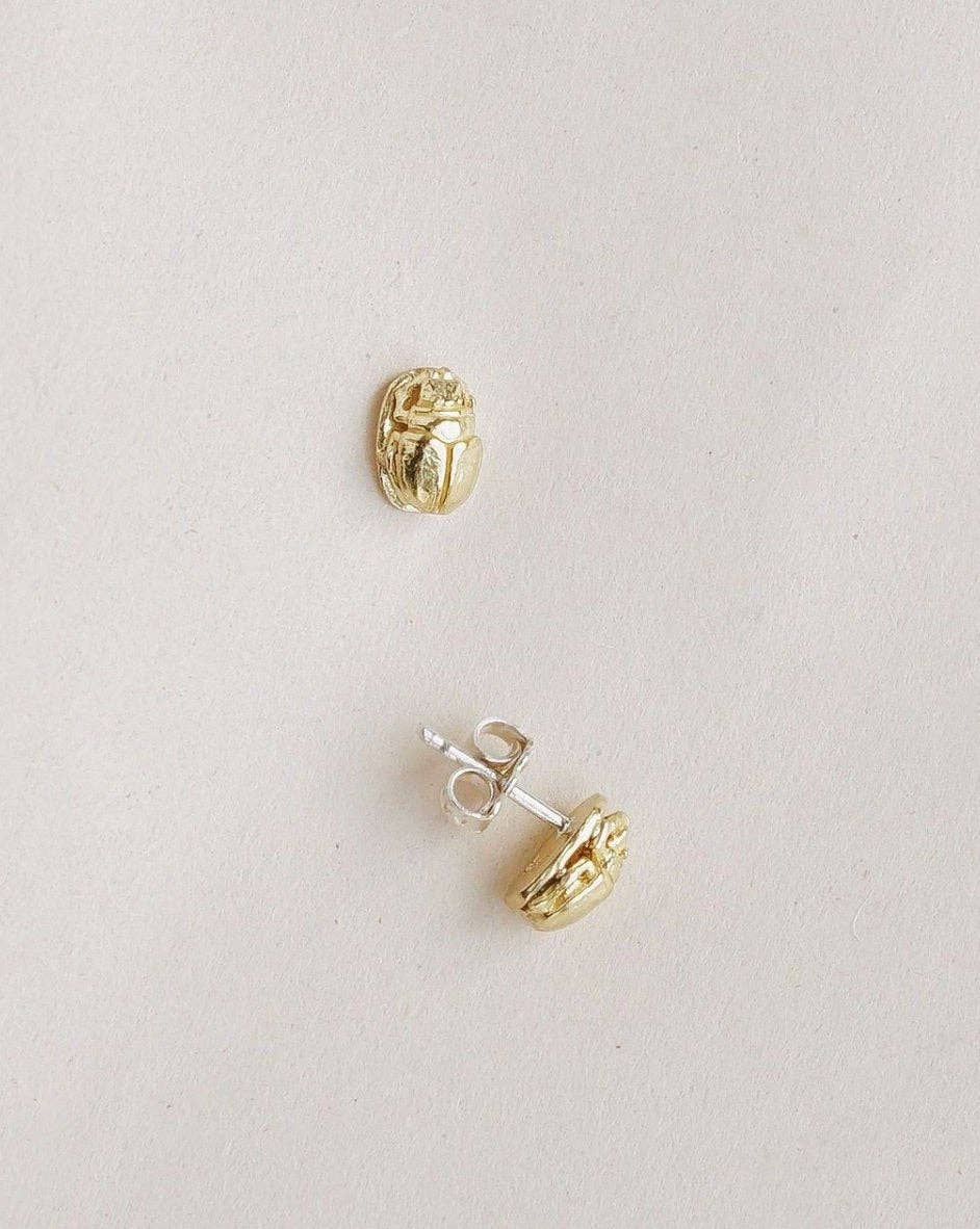 Scarab Stud gold scarab earrings on a light background