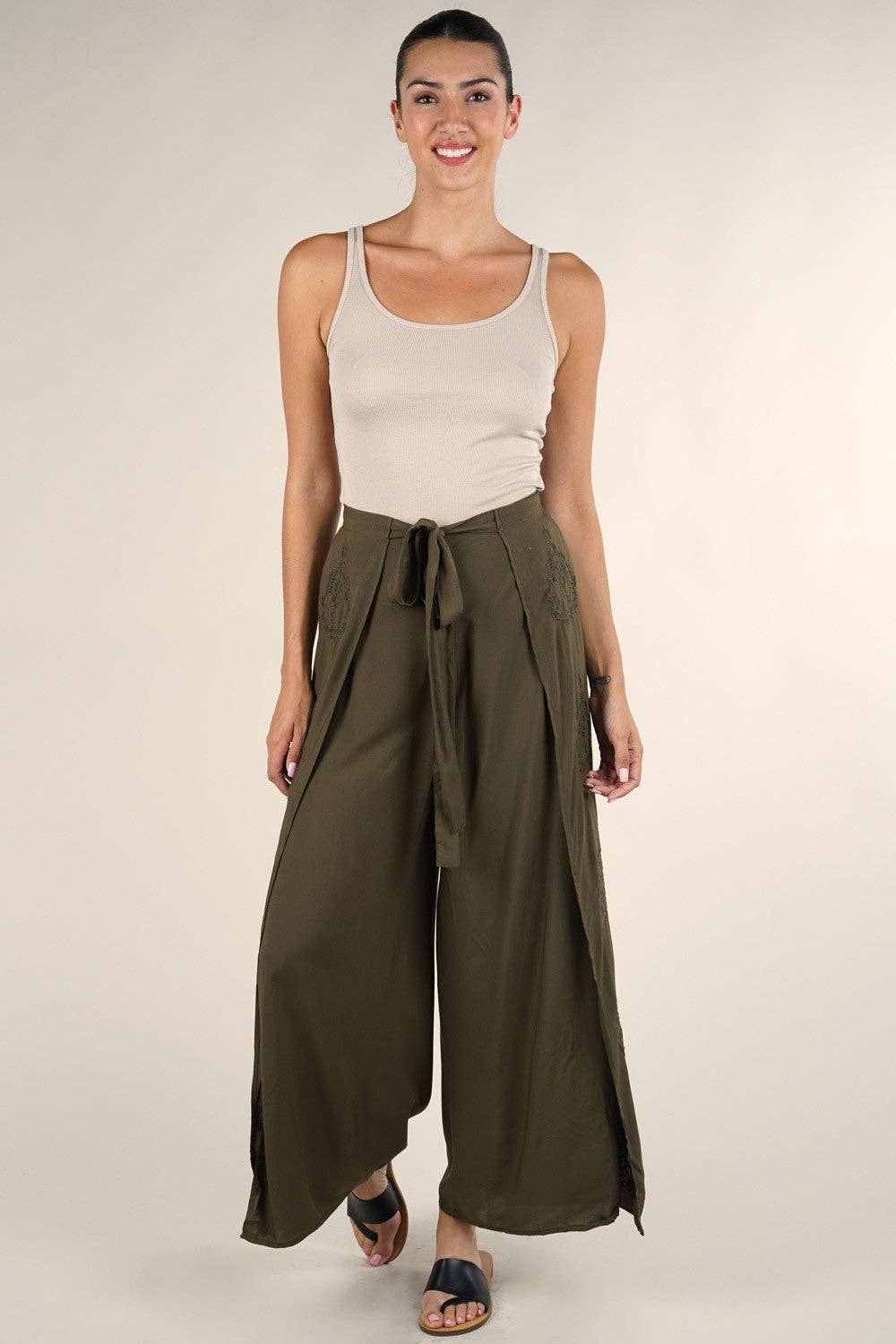 Woman wearing green Boho Beach Light Weight Wrap Pant with wide legs and tied waist, paired with a beige tank top