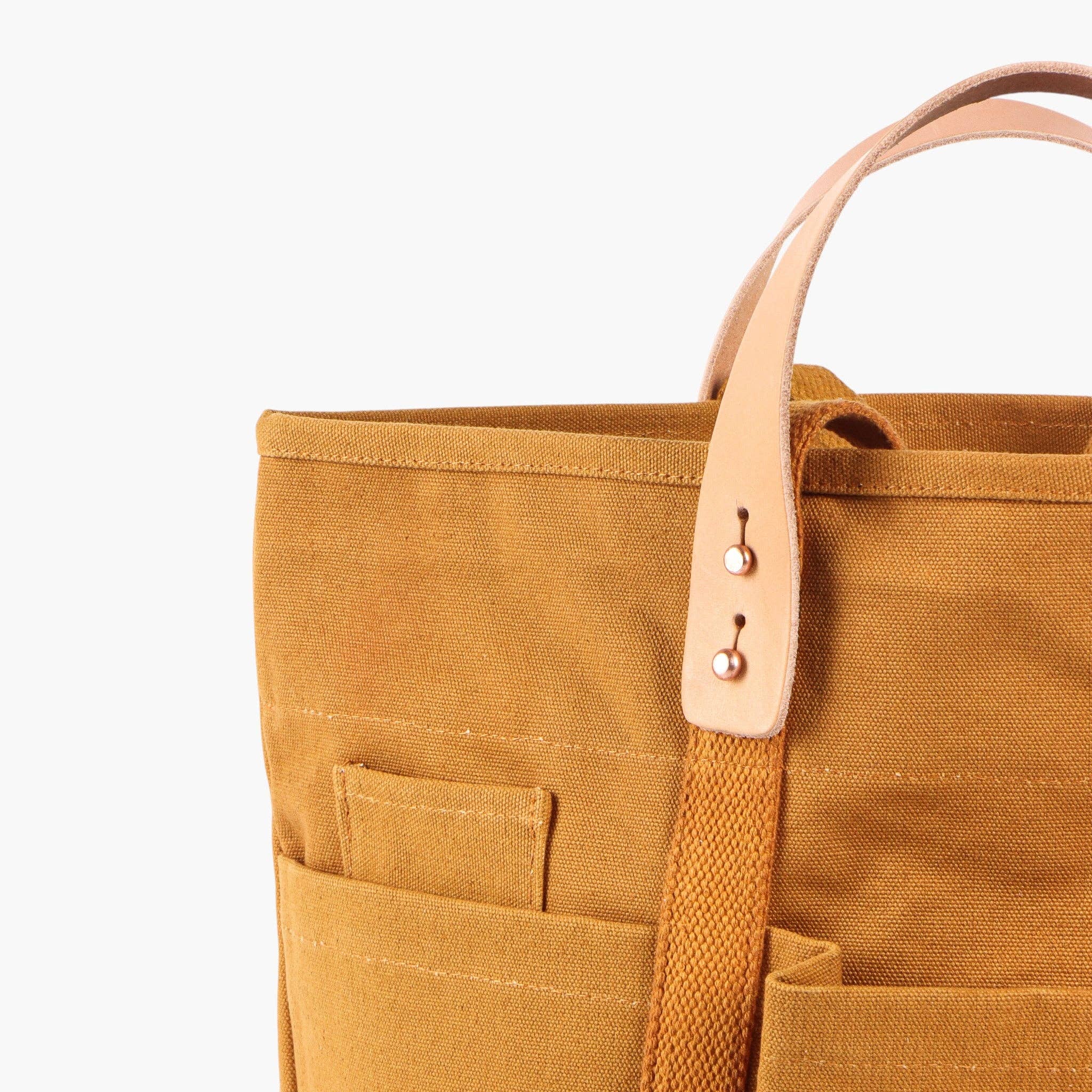 Construction Tote | Mustard Seed with durable canvas, leather handles, and spacious exterior pockets for everyday styling and use.