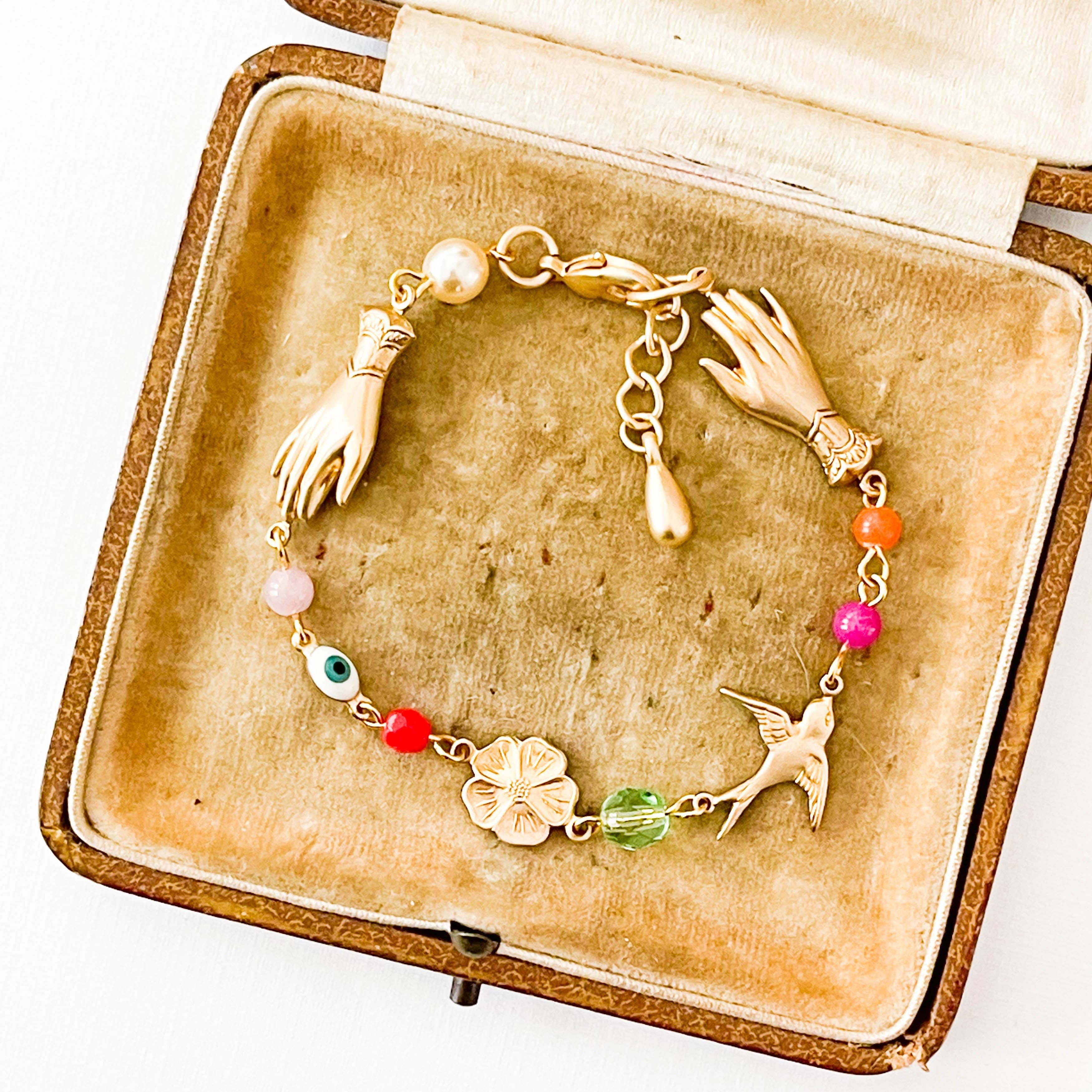 Adjustable Evil Eye Charm Bracelet With Pearl And Beads featuring gold charms and colorful beads in a vintage box