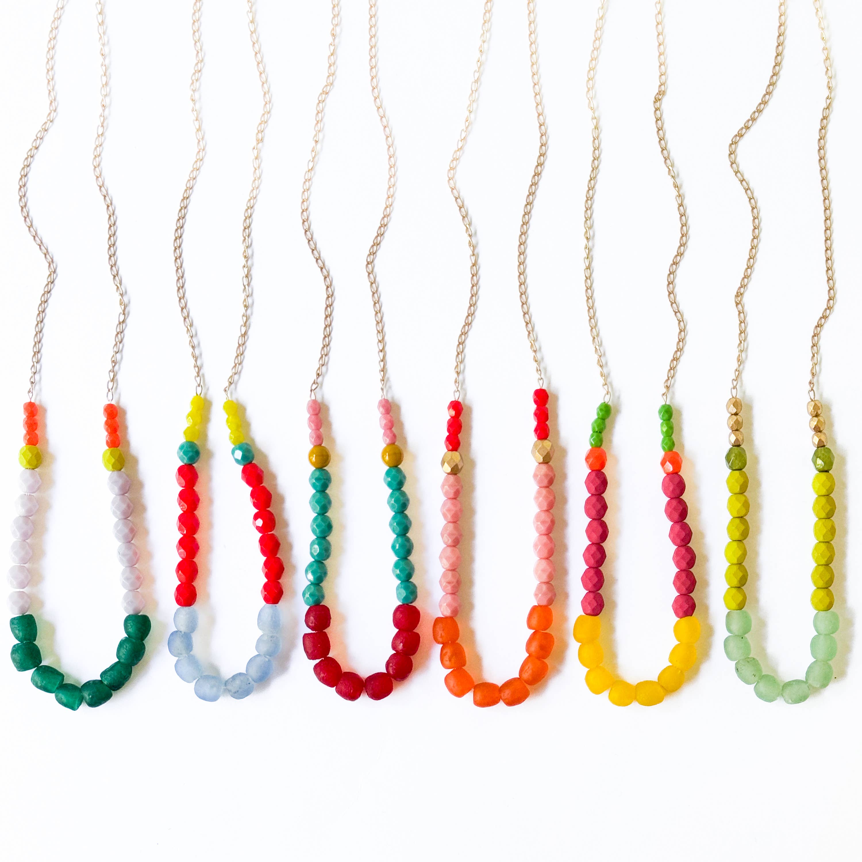 Multicolor Recycled African Glass And Mixed Bead Necklace in various vibrant colors with gold and silver chains laid flat on white background