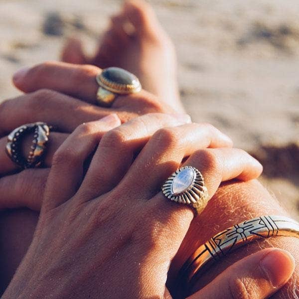Close-up of hands wearing Medicine Wheel Cuff || Men and artisan rings with natural light on skin.