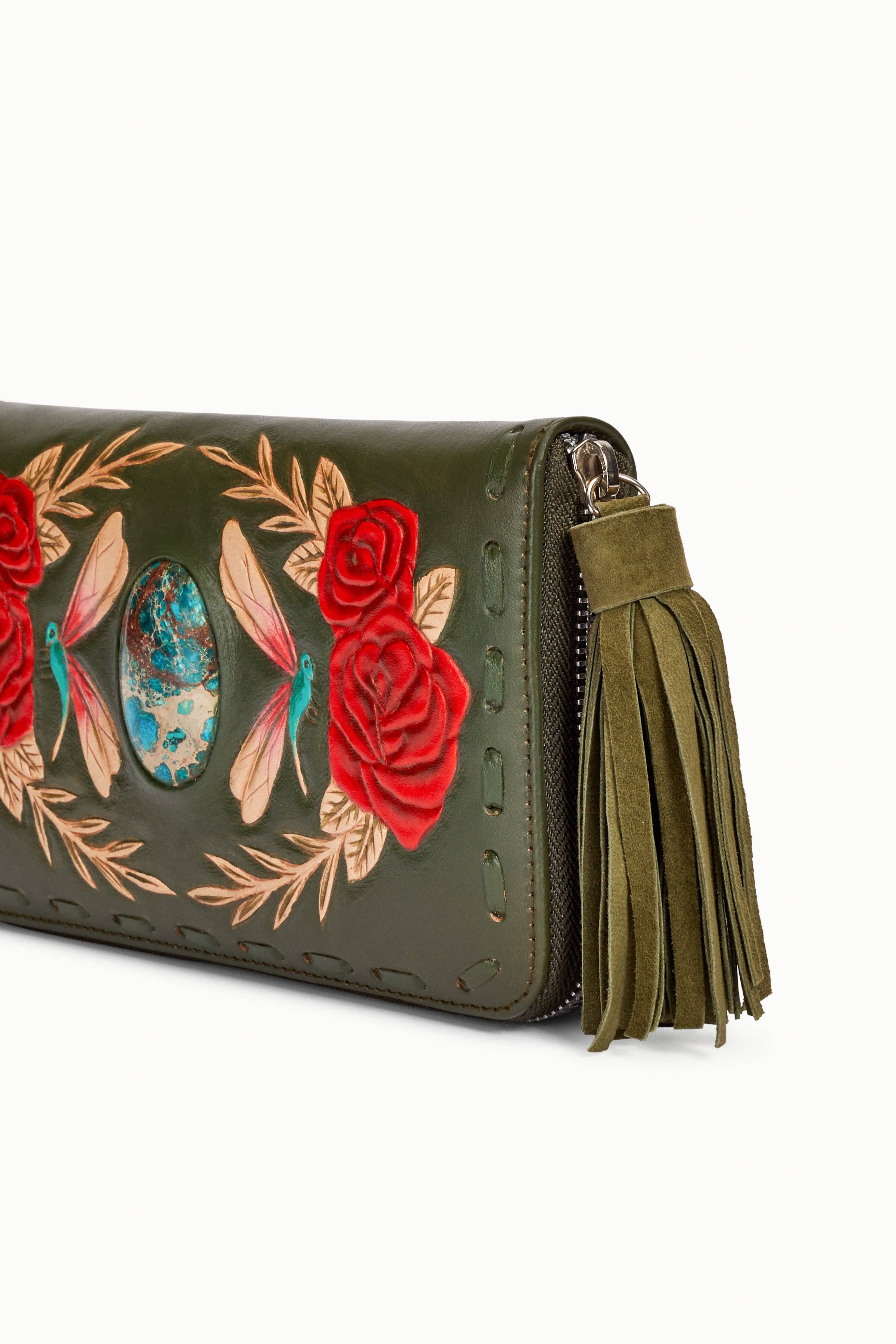 The Akaroa Rose Wallet Olive by Jodi Lee is a hand-tooled green leather wallet with embroidered red roses, dragonflies, golden leaves, a turquoise stone centerpiece, and a large green suede tassel zipper pull.
