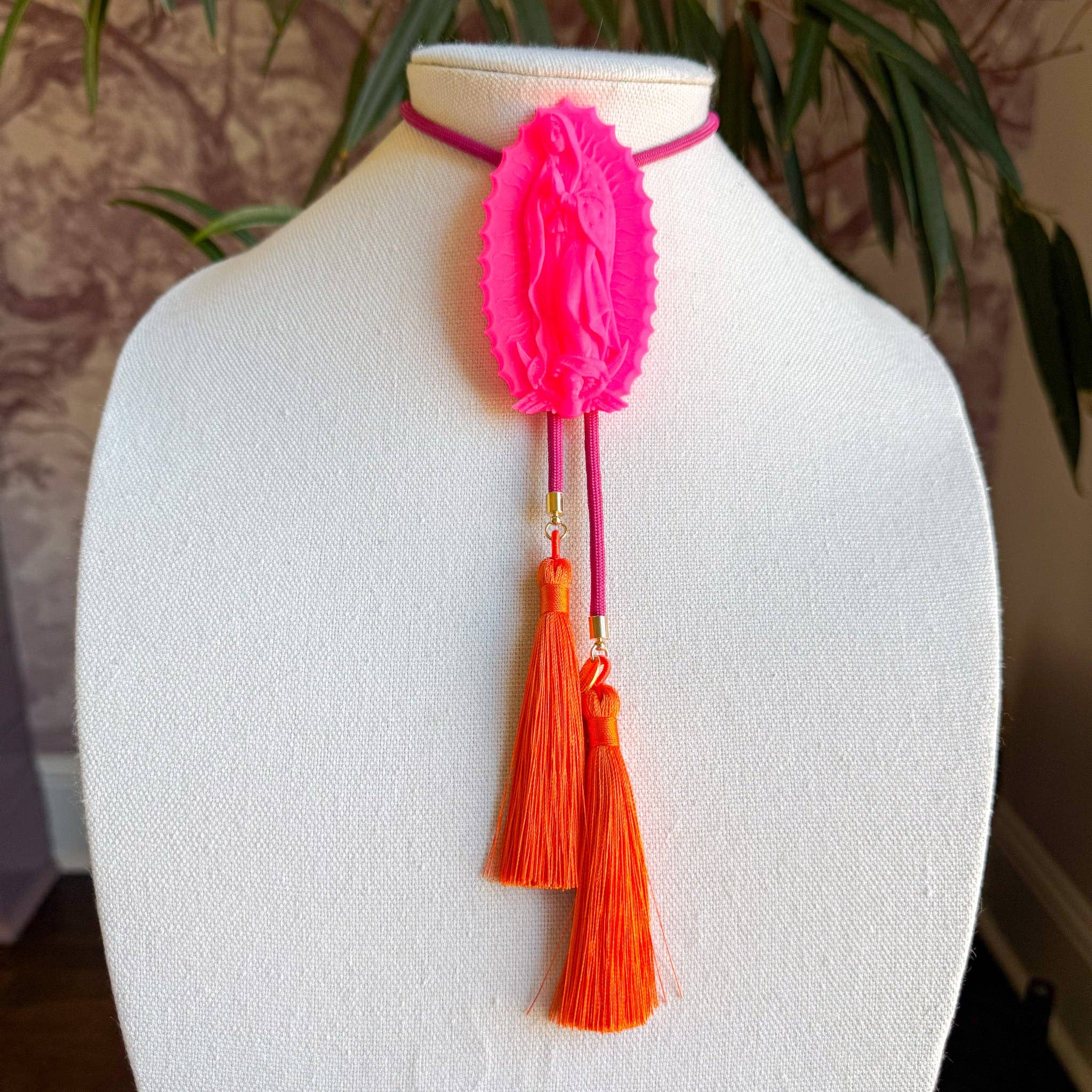 Our Lady of Glitterati Bolo Neon Pink with Fuchsia & Orange featuring a neon pink centerpiece and orange tassels on a fuchsia cord