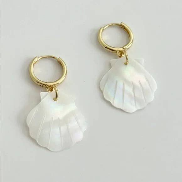 The Scallop Hoop Earrings by Tramps+Thieves feature gold-filled hoops with white iridescent shell-shaped pendants, showcased elegantly against a simple, light background.