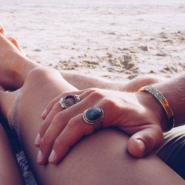 Medicine Wheel Cuff || Men worn on wrist with two rings by the beach, capturing a relaxed, artisanal style moment.