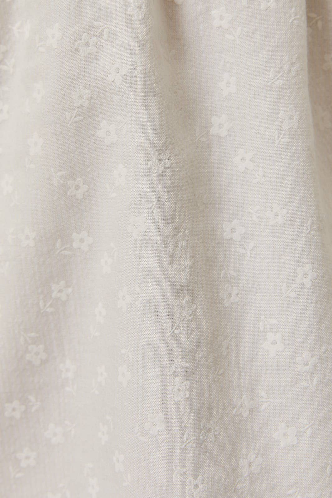 Close-up of delicate floral pattern on fabric of Shirred Neck Low Waist Mini Dress in soft neutral tones