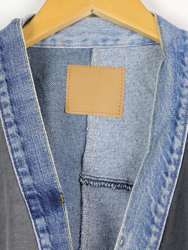 Close-up of collar and inner stitching details on Upcycled Patchwork Denim Jacket hanging on wooden hanger