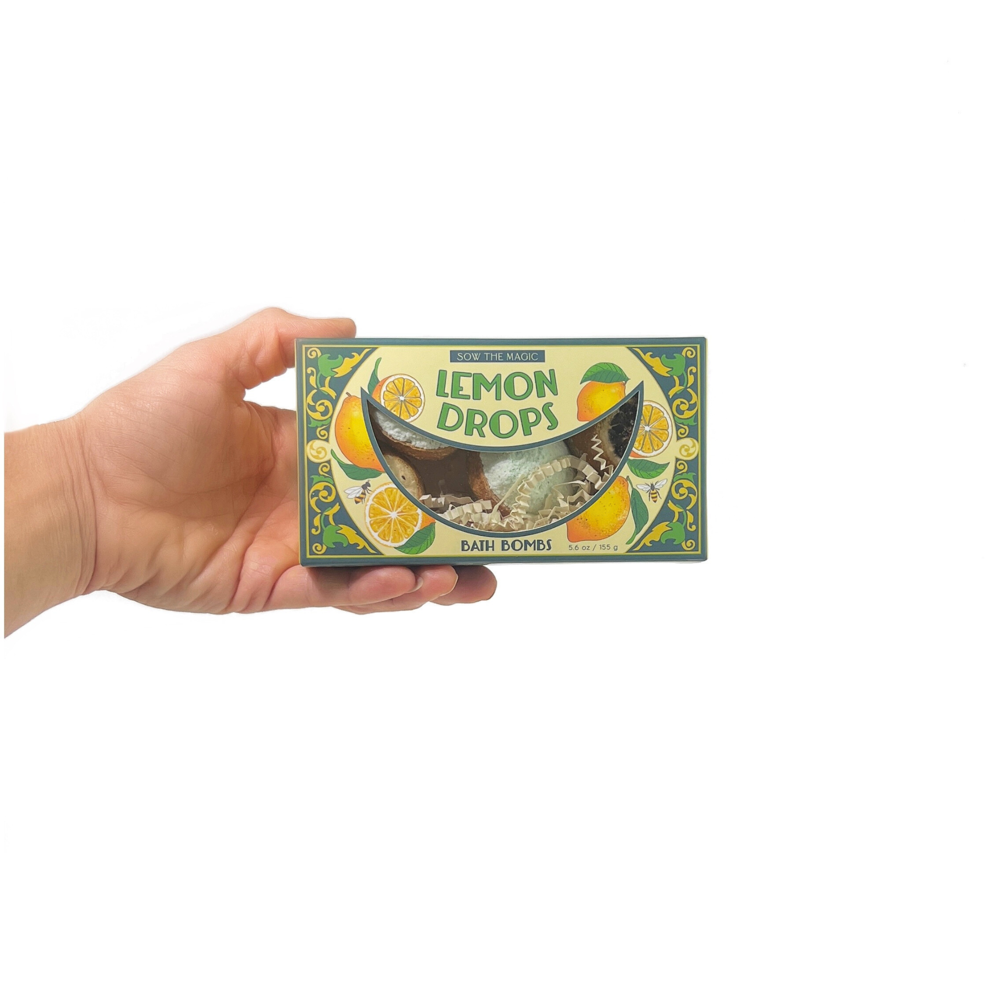 Natural Lemon Drop Bath Bomb Gift Set made with Lemon + MInt held in hand with decorative lemon design packaging background