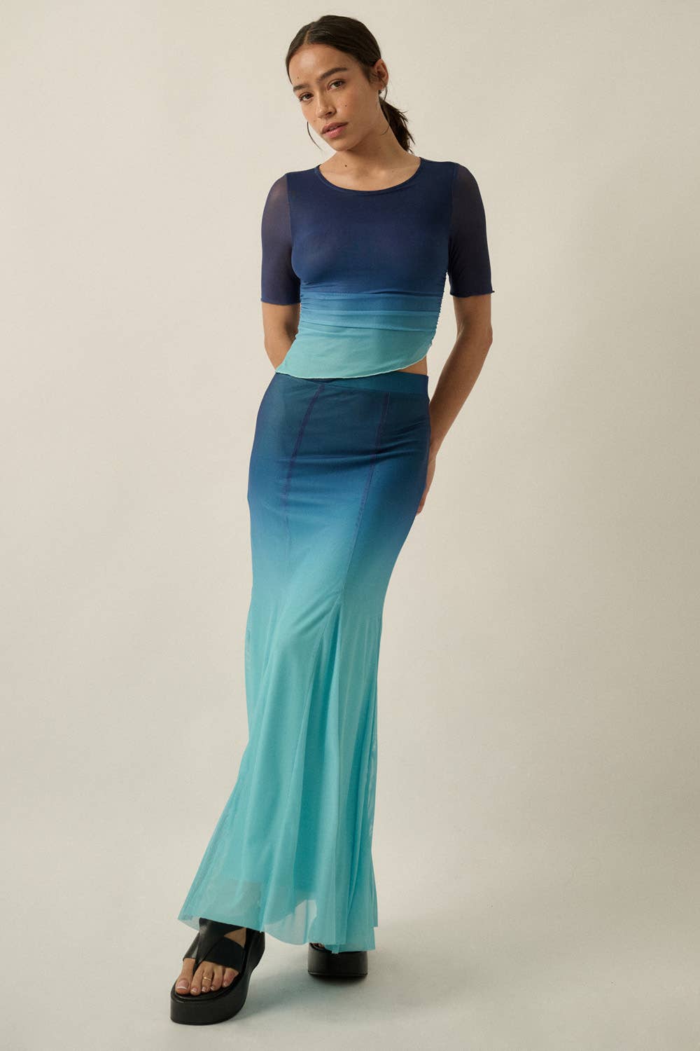 Woman wearing Ombre Mesh Fit-and-Flare Godet Maxi Skirt with a layered ombre effect in blue and turquoise tones
