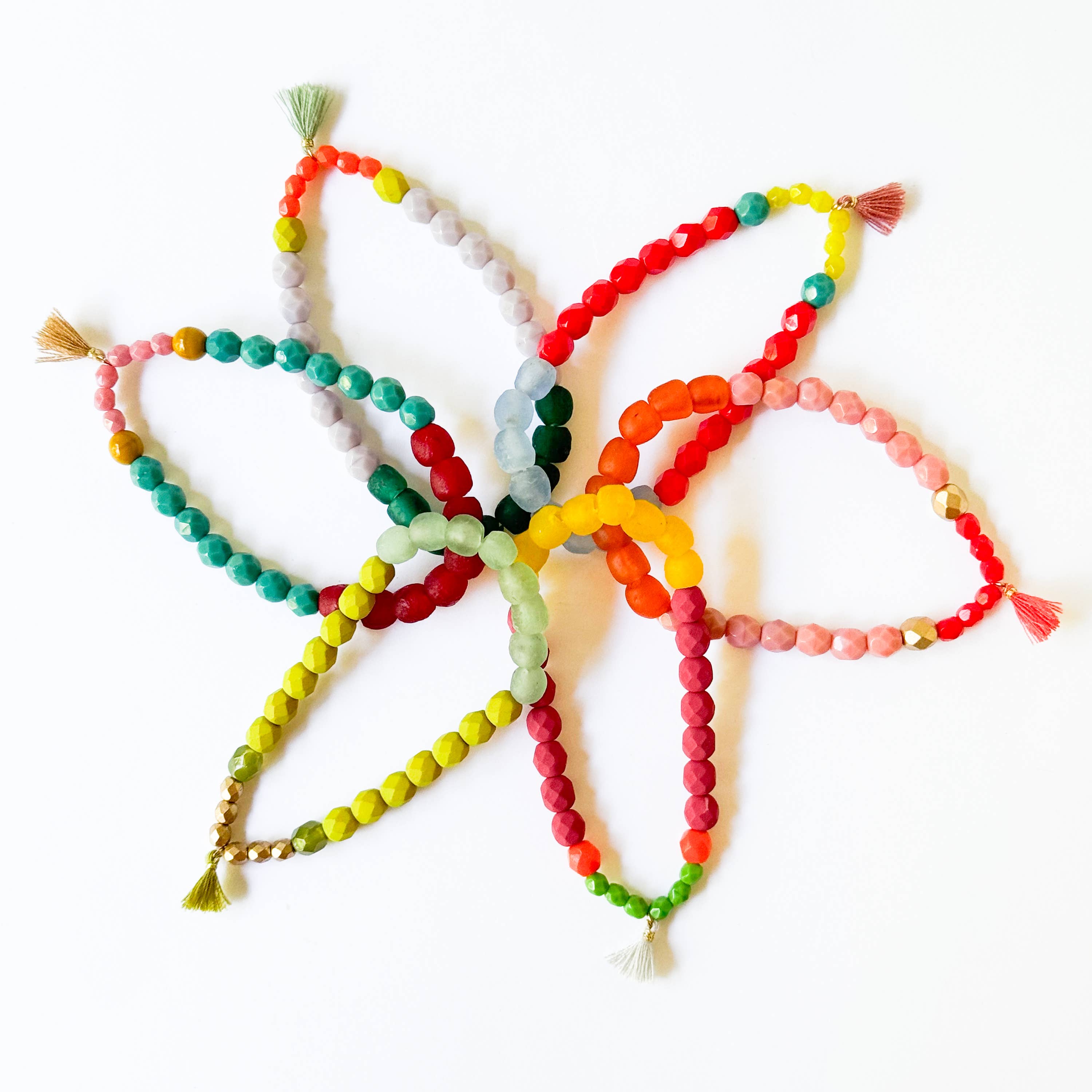 Multicolor Recycled African Glass And Mixed Bead Bracelet arranged in colorful overlapping loops with tassel ends on white background