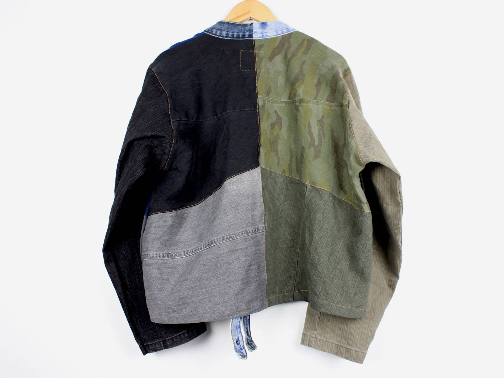 Upcycled Patchwork Denim Jacket with mixed fabric panels in black, gray, olive, and camo for bold everyday styling