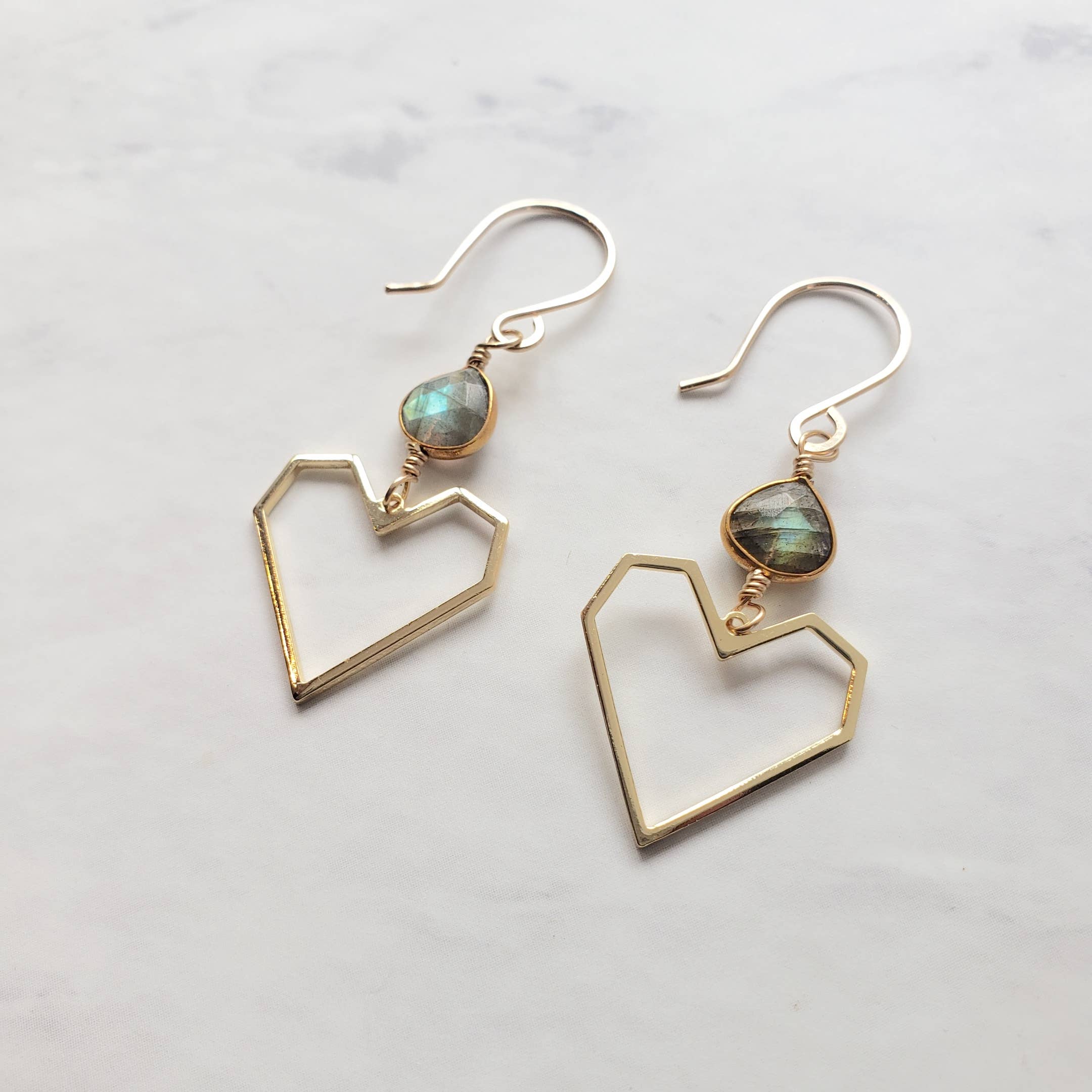 Dreamers of Dreams Geometric Heart Labradorite Earrings feature 14K gold fill and faceted teardrop labradorite, shown on a white marble surface.