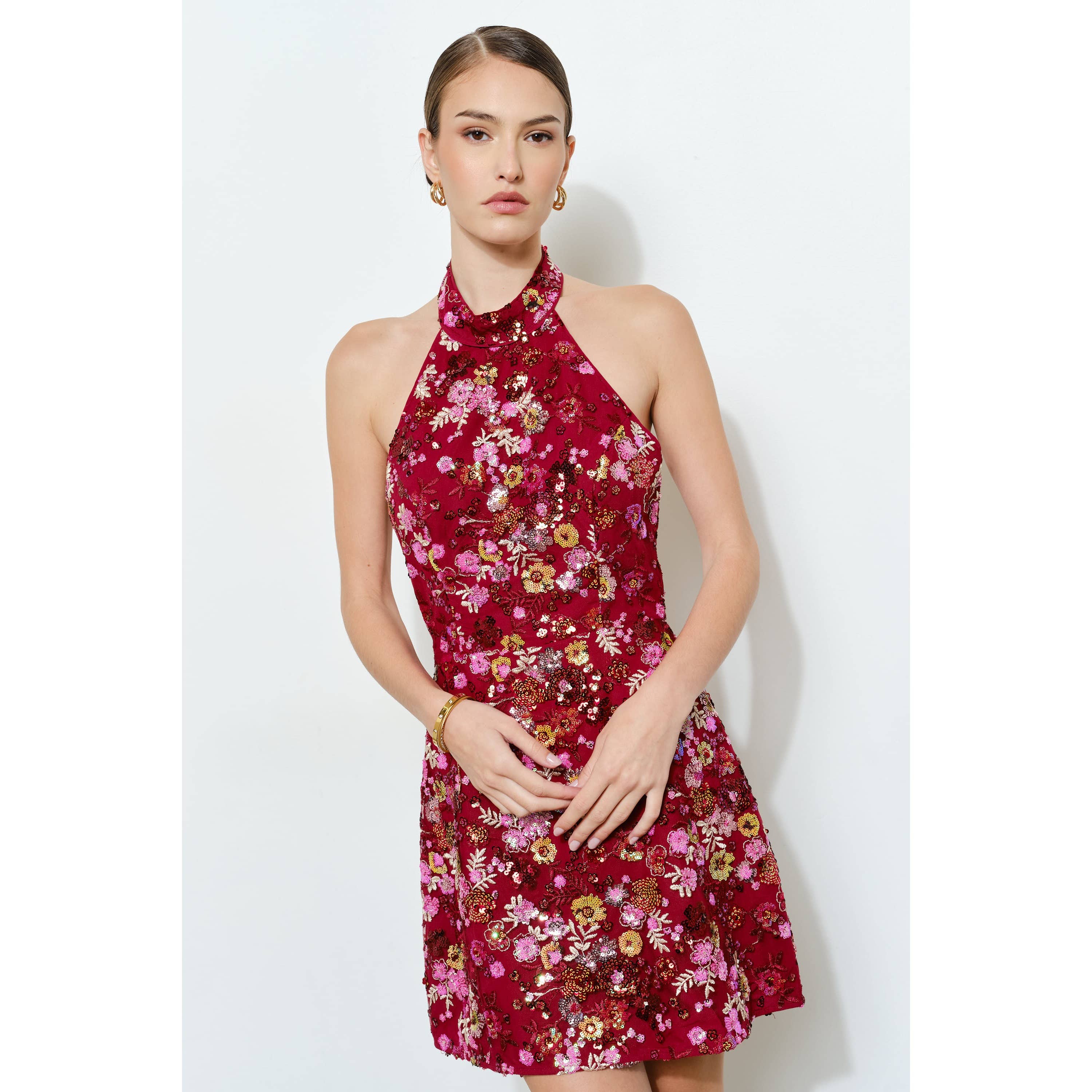Model wearing a vibrant Floral Sequins Embellished Halter Neck Mini Dress with detailed floral patterns and sparkling accents