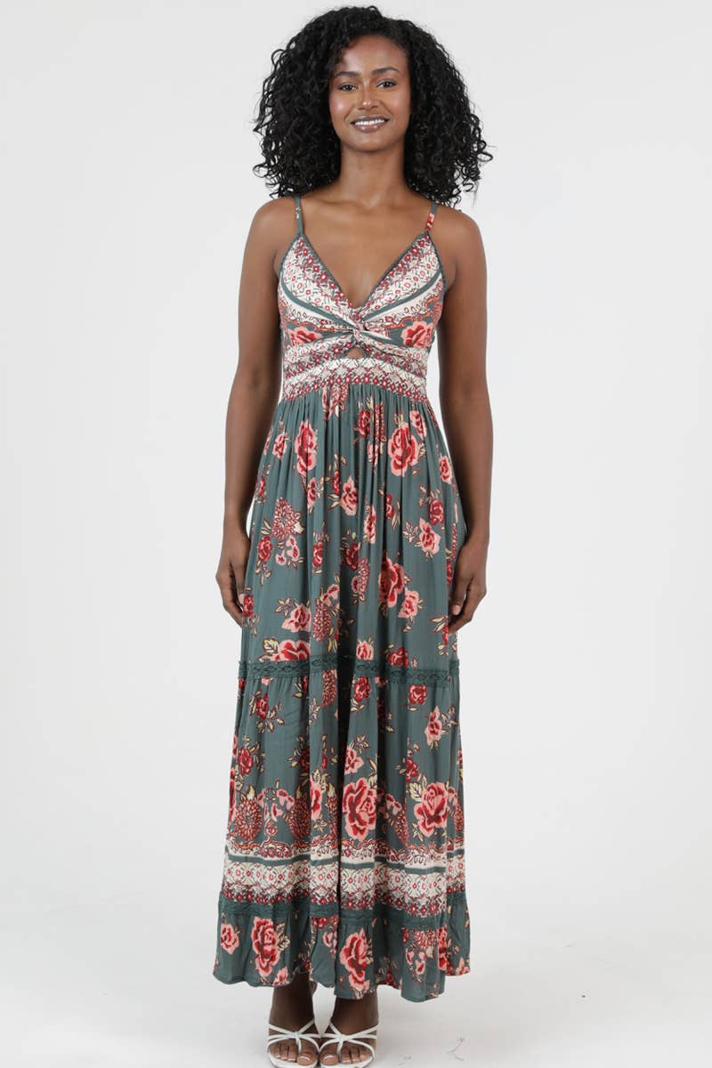 Woman wearing a floral printed Golden Hour Twist Maxi Dress with thin straps and a twisted bodice detail