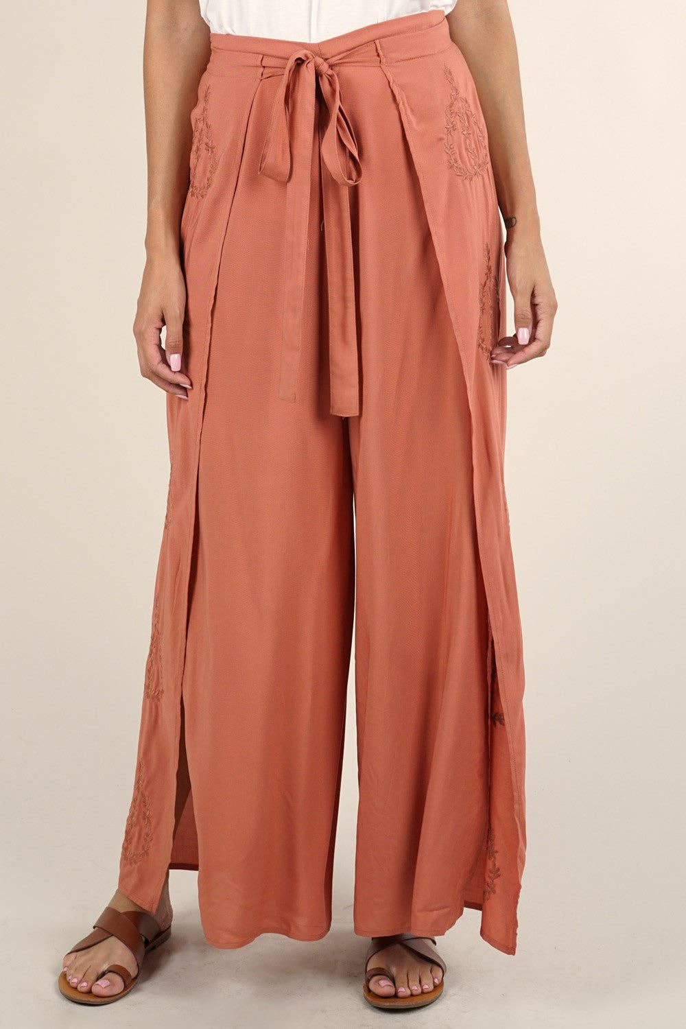 Front view of rust-colored Boho Beach Light Weight Wrap Pant with tie waist and relaxed fit worn with sandals