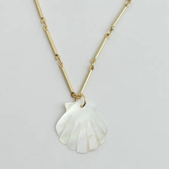 The Tramps+Thieves Muna Shell Necklace features a gold chain and an iridescent white mother of pearl seashell pendant, shown against a light background.