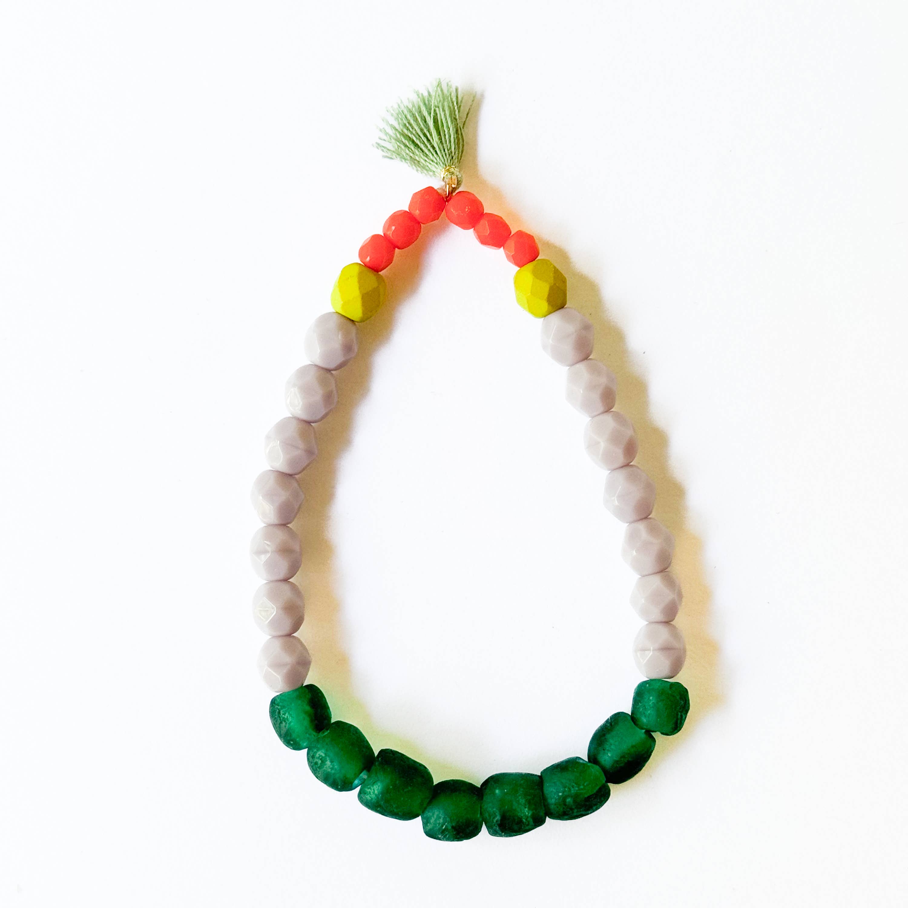 Multicolor Recycled African Glass And Mixed Bead Bracelet featuring vibrant green, gray, yellow, and red beads with tassel detail.