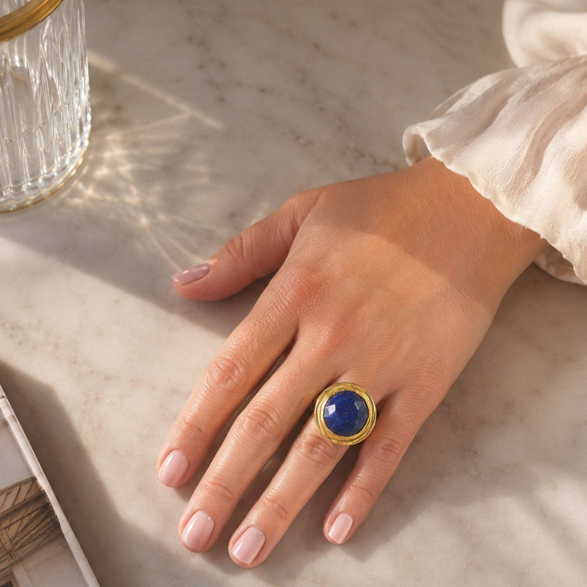 Eylul Lapis Lazuli Cocktail Ring with blue stone and gold tone setting worn on hand