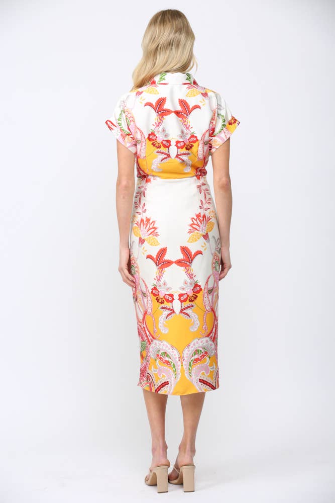 Back view of a woman wearing BOTANIC SCARF PRINT SELF TIE WAIST BUTTON DOWN DRESS with colorful floral patterns and rolled sleeves