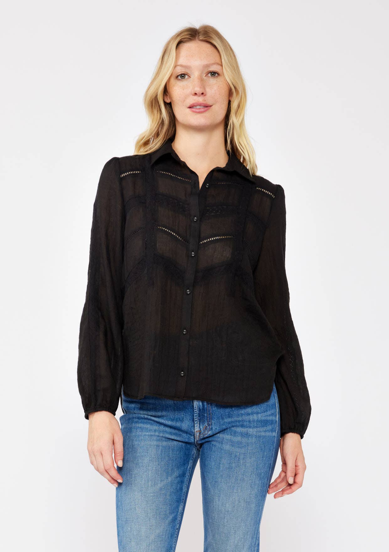 Woman wearing a black Crinkled Lace Long Sleeve Button Down Blouse paired with blue jeans against white background