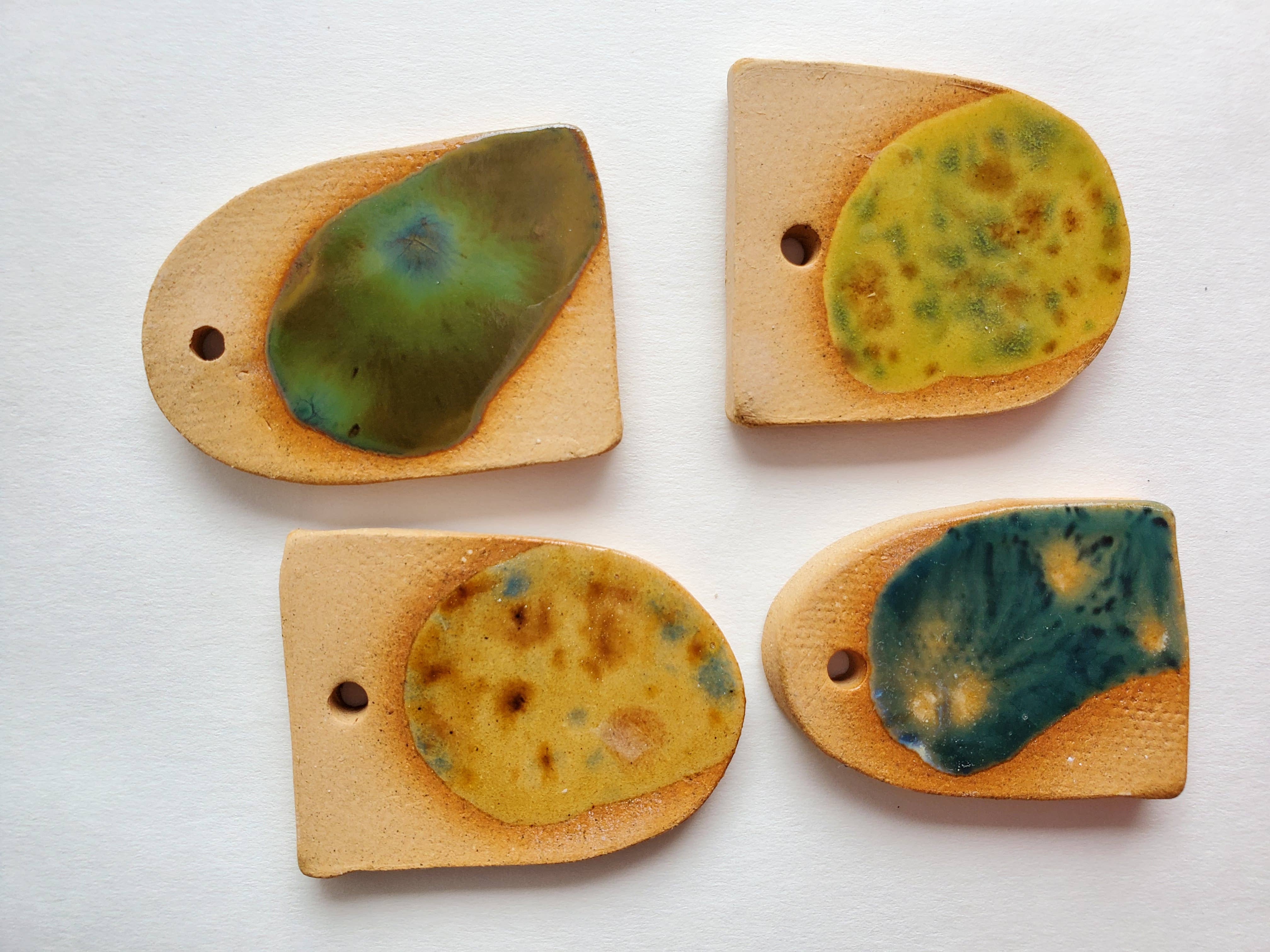 Handcrafted ceramic pieces with green and blue glaze accents, styled as unique Cactus ornament parts.