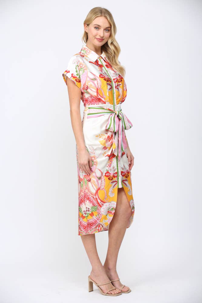 Woman wearing BOTANIC SCARF PRINT SELF TIE WAIST BUTTON DOWN DRESS with colorful bohemian pattern and short sleeves