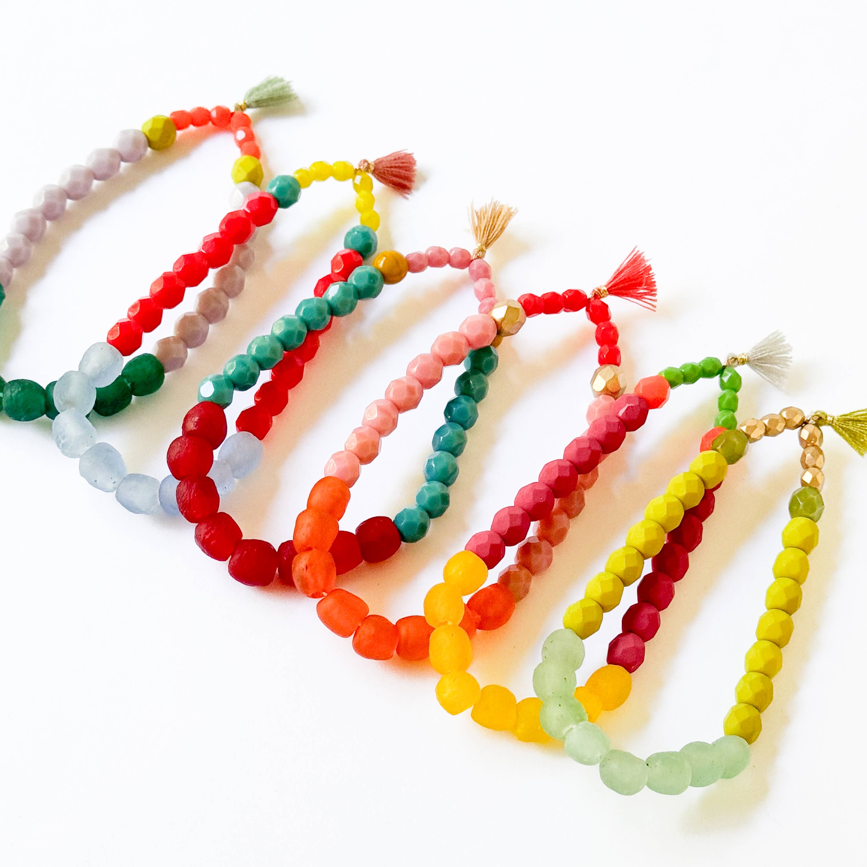Multicolor Recycled African Glass And Mixed Bead Bracelet featuring vibrant beads and small decorative tassels in varied color combinations