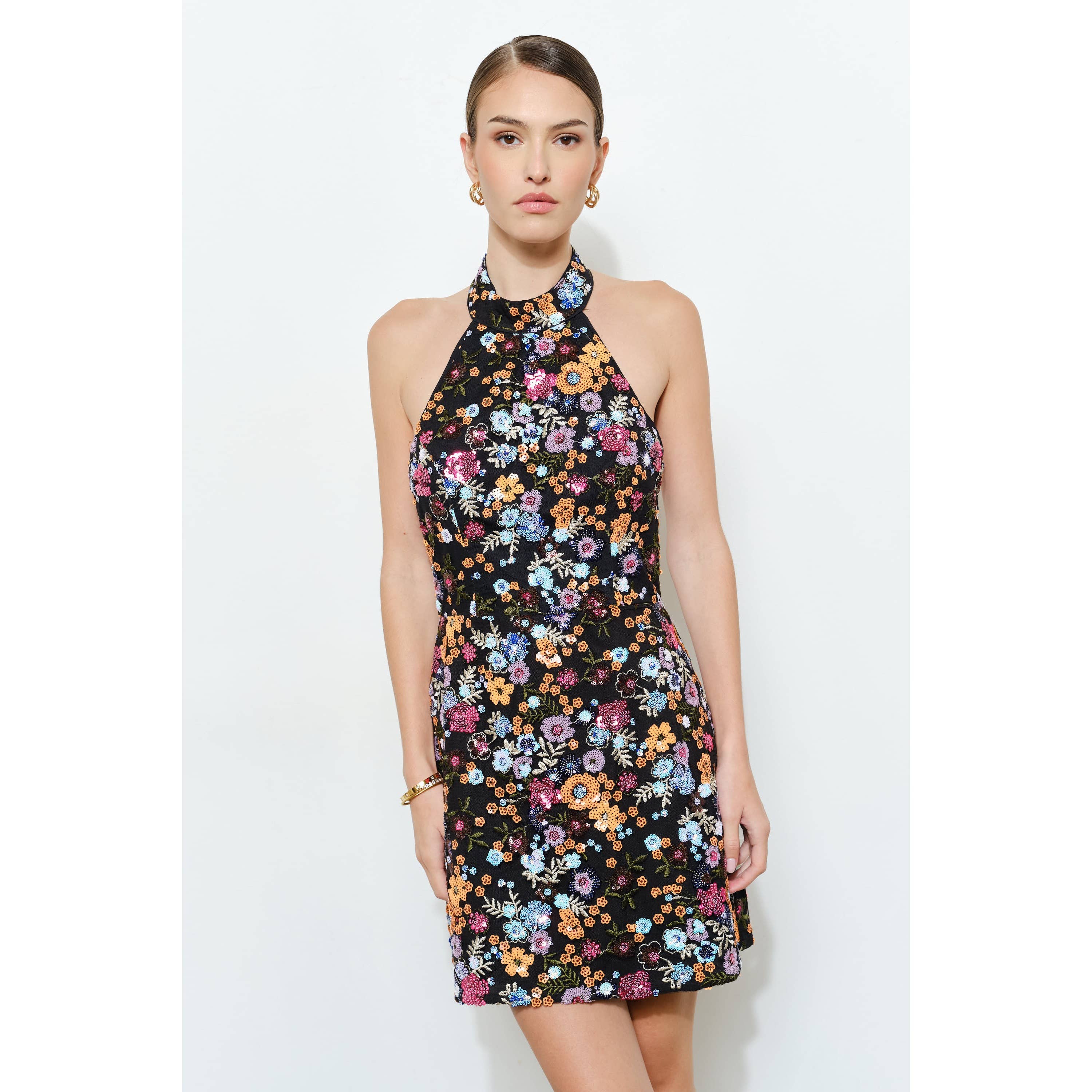 Woman wearing a Floral Sequins Embellished Halter Neck Mini Dress with colorful floral patterns on black fabric