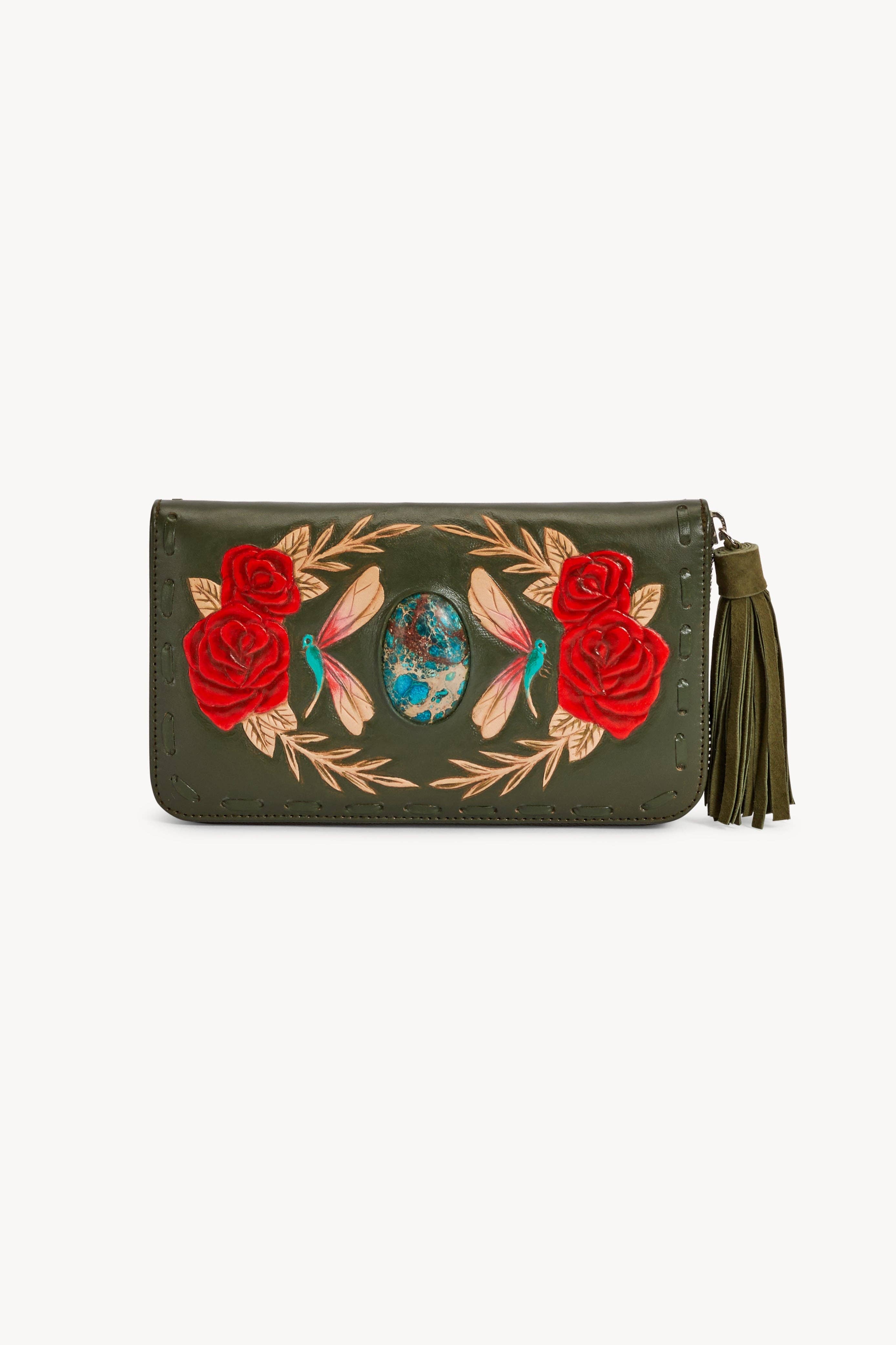 The Jodi Lee Akaroa Rose Wallet Olive is an artisanal green clutch with a tassel zipper, embroidered red roses, leaves, insects, and an oval blue and brown turquoise gemstone centerpiece.