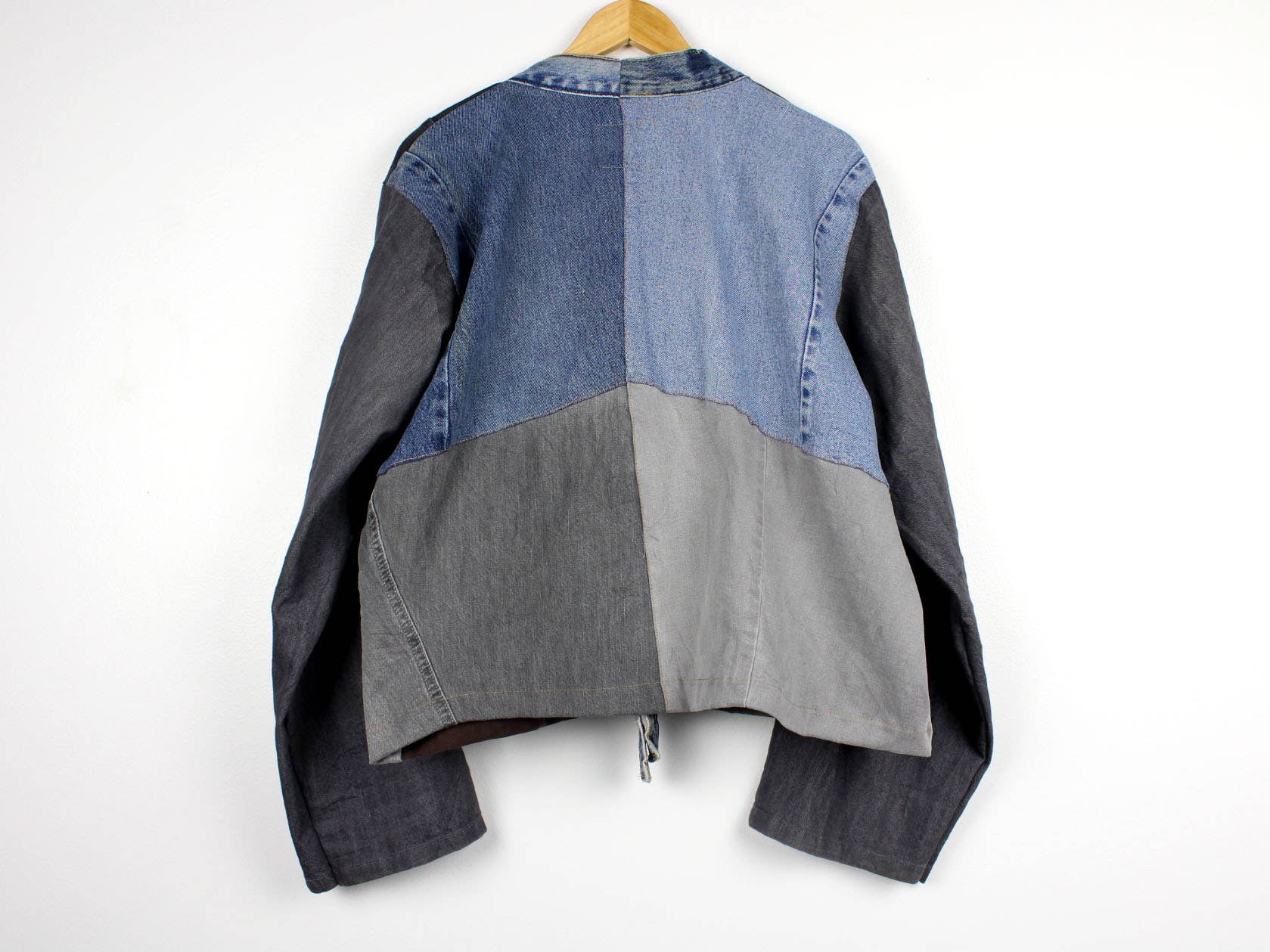 Upcycled Patchwork Denim Jacket shown from back, featuring mixed blue and gray denim panels for a unique look