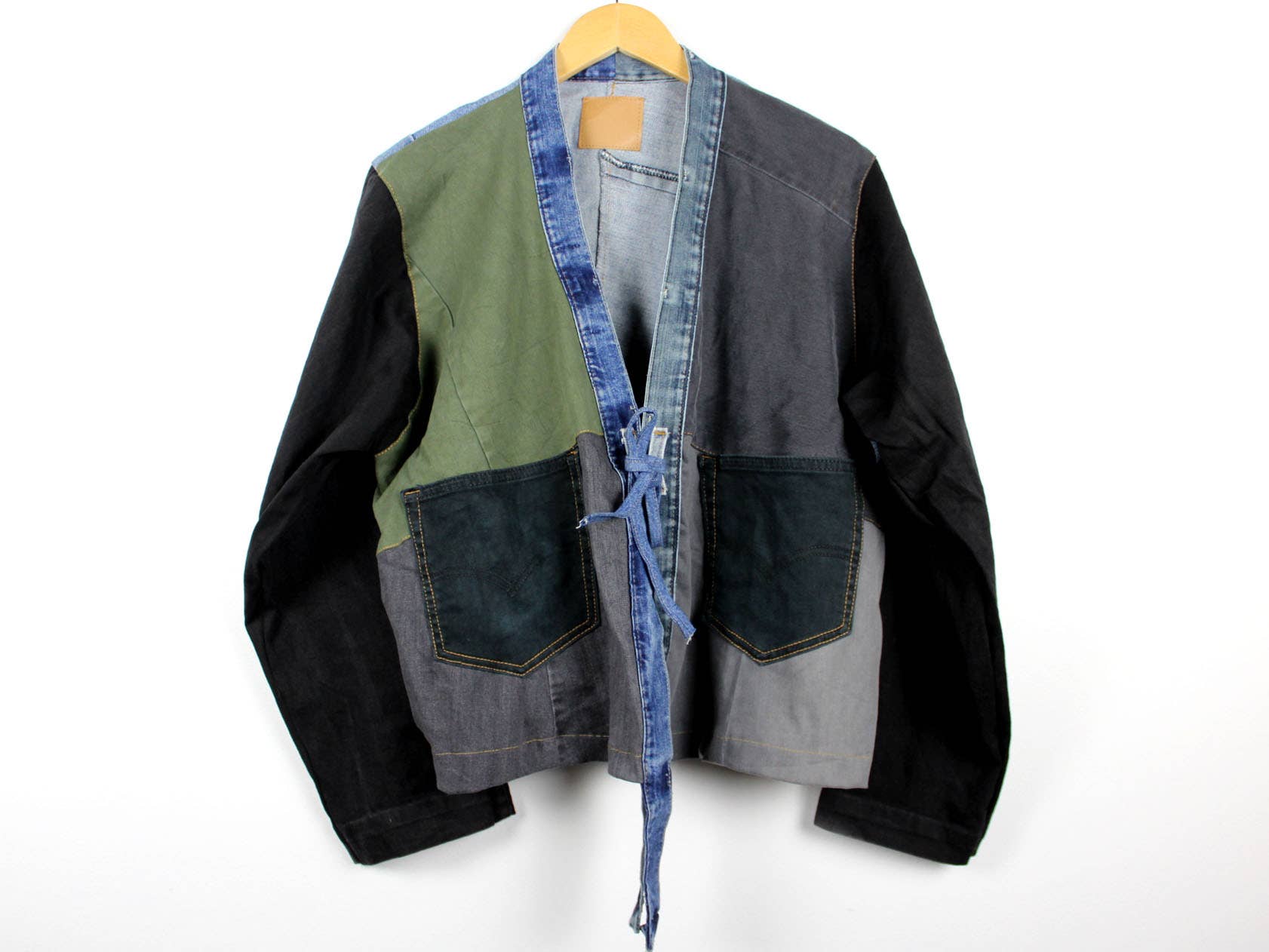 Upcycled Patchwork Denim Jacket with green, black, gray panels and denim trim, featuring front pockets and tie closure
