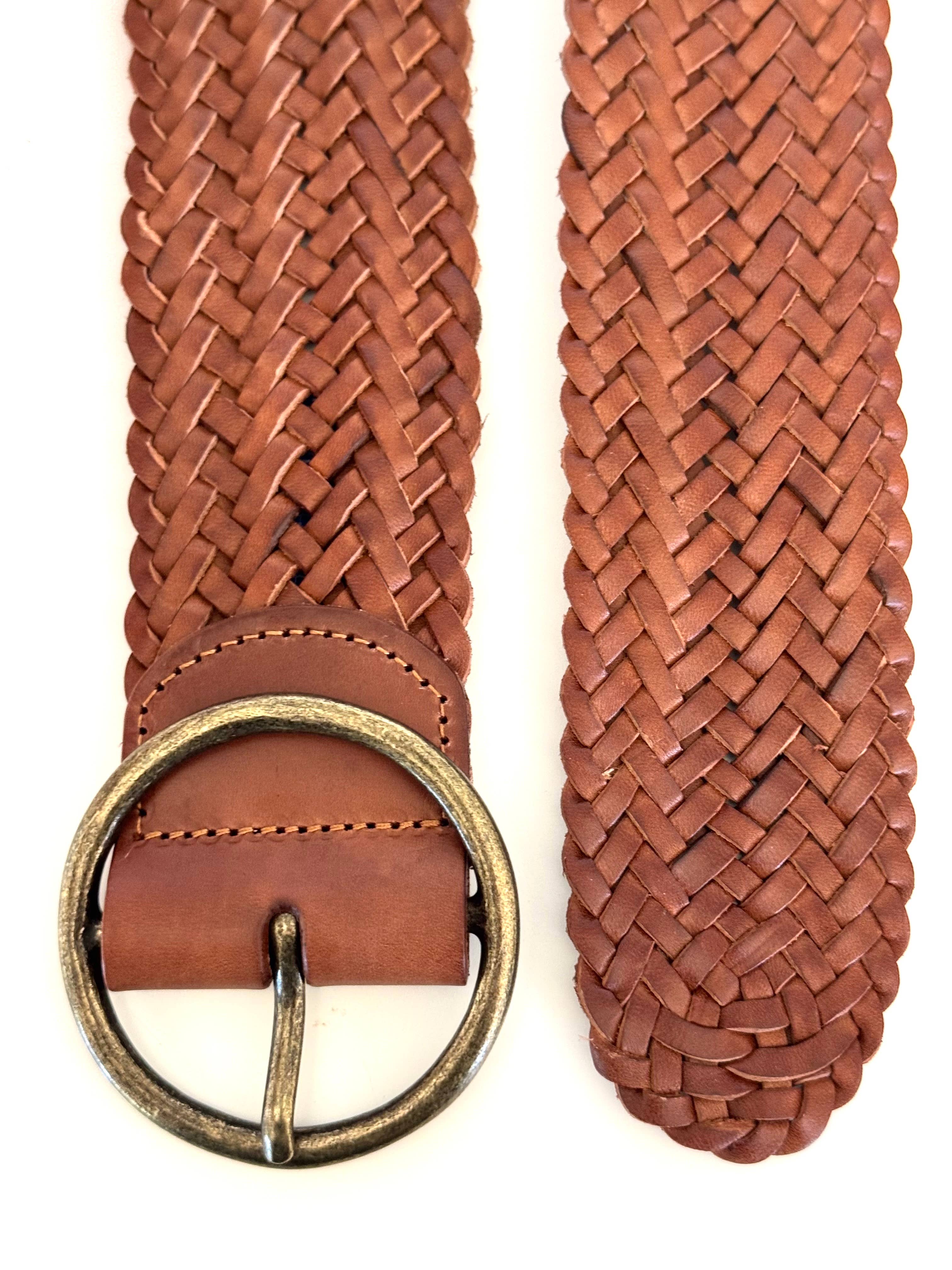 Close-up of Ginger Blue’s Classic Wide Braided Leather Belt in Cognac, showing intricate woven leather and fine stitching, laid flat to display its round brass buckle and expert craftsmanship.