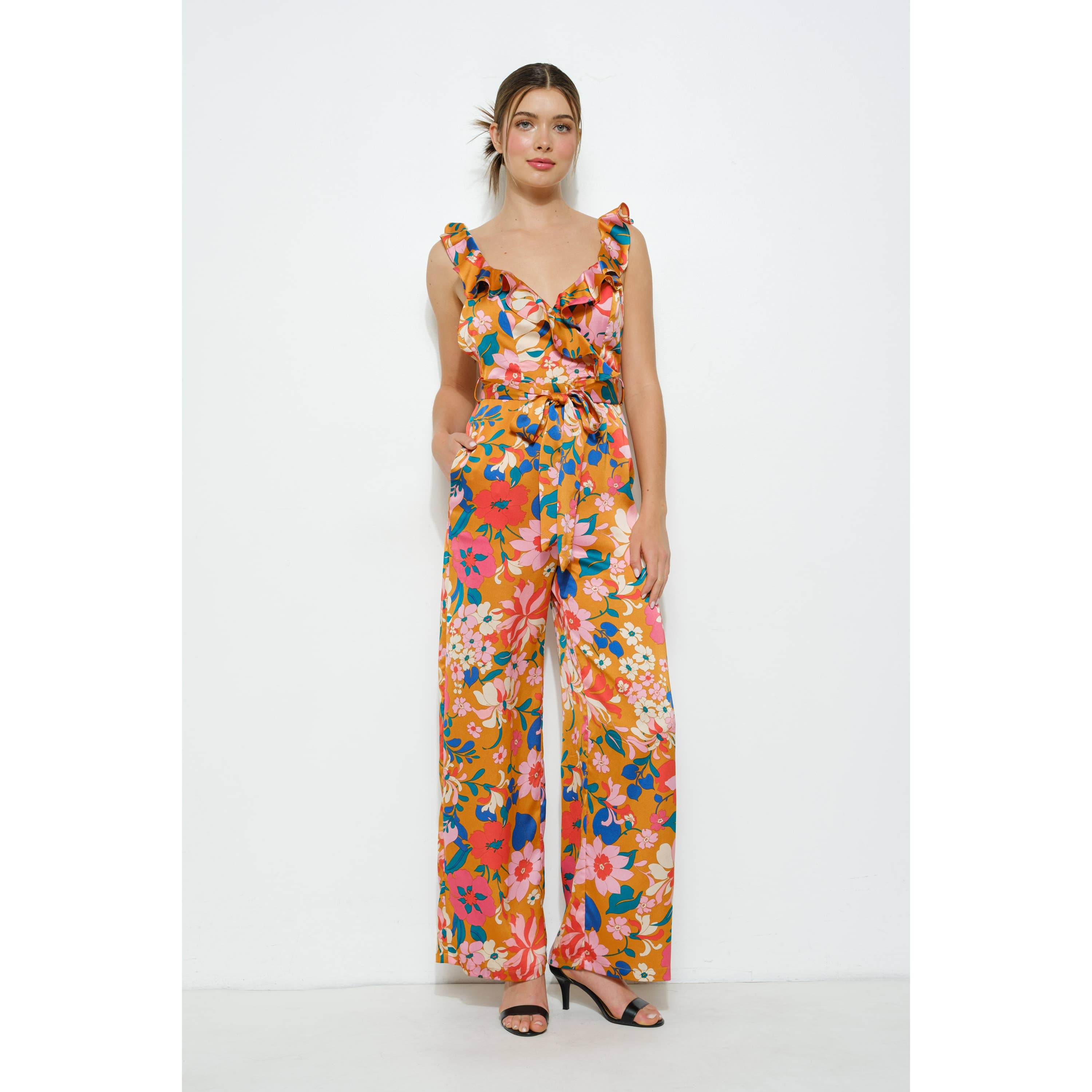 Woman wearing a colorful floral jumpsuit on a white background