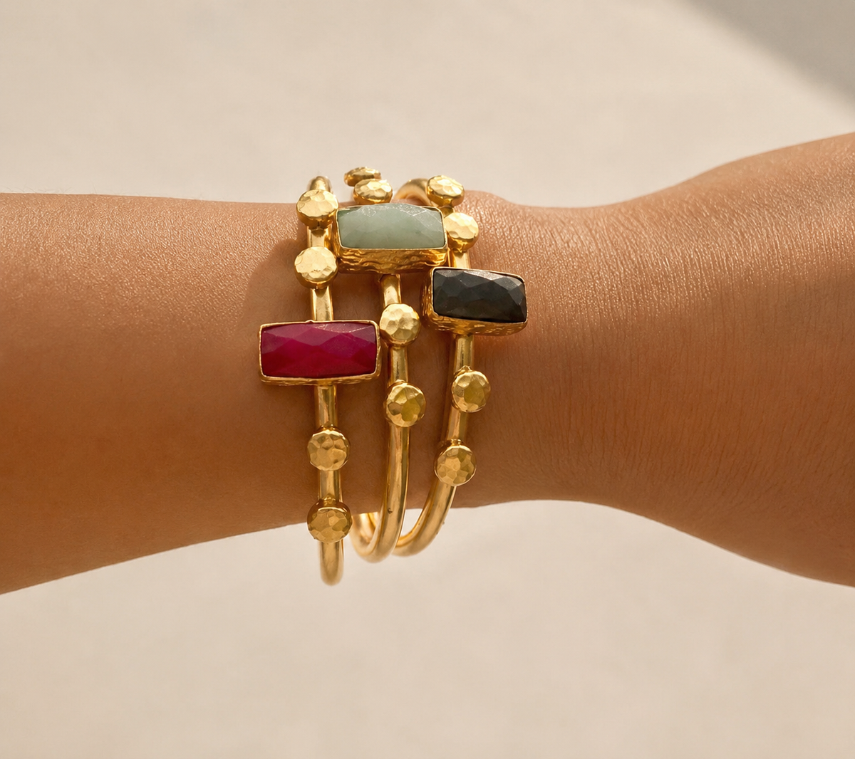 Harem Ruby Bangle with gold bands and colorful gemstones styled on a wrist