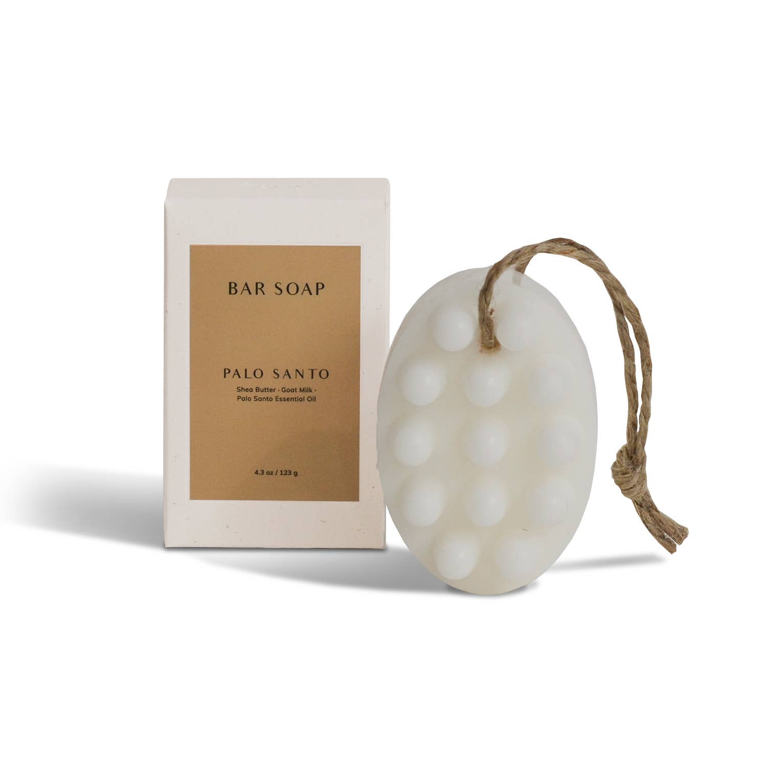 An oval, white handmade Cedar and Myrrh Palo Santo + Shea Butter Bar Soap with raised bumps and a rope loop sits beside its box—ideal for sensitive skin care and gentle Palo Santo cleansing.