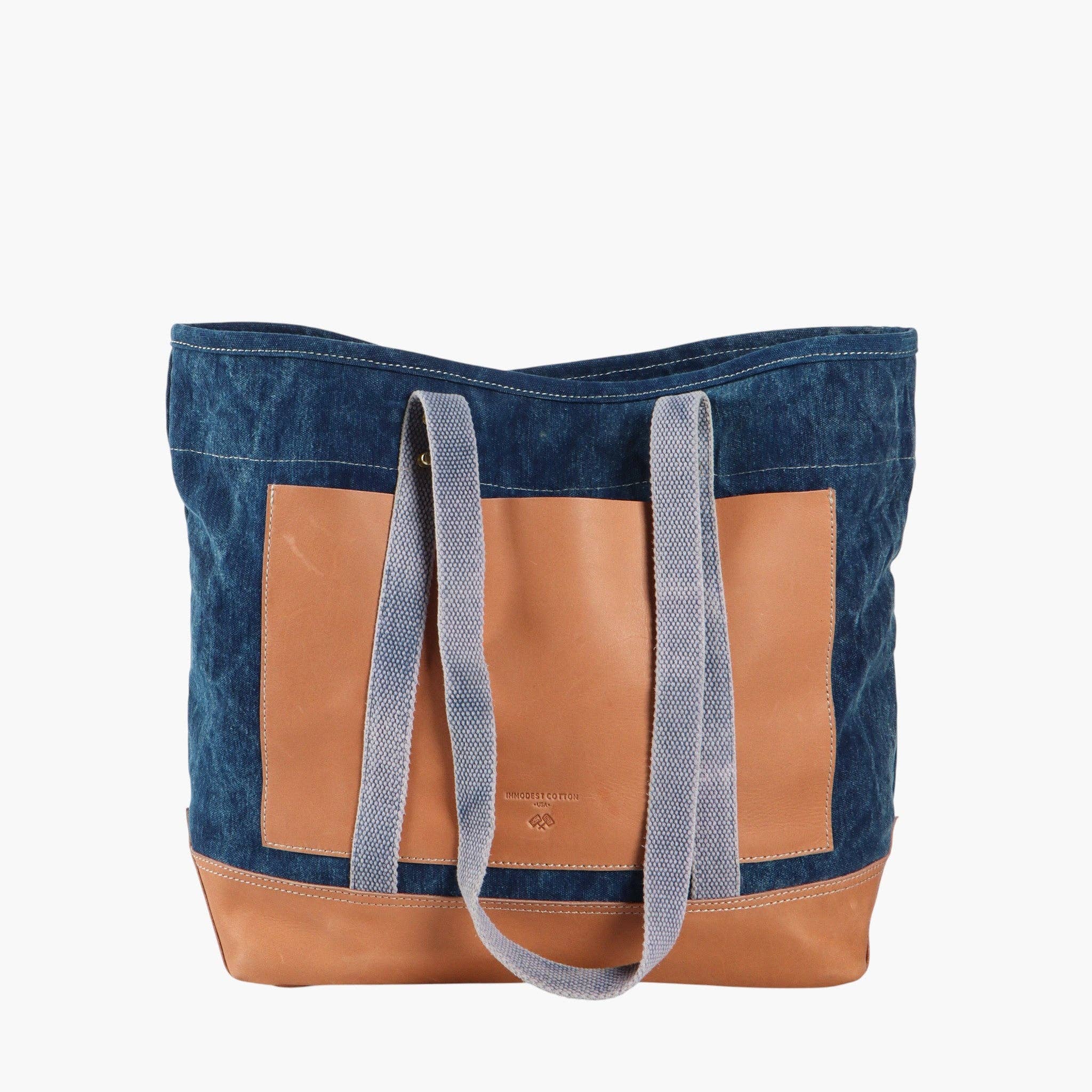 Editor Tote | Indigo + Tan with canvas body, tan leather base and pocket, and durable fabric shoulder straps