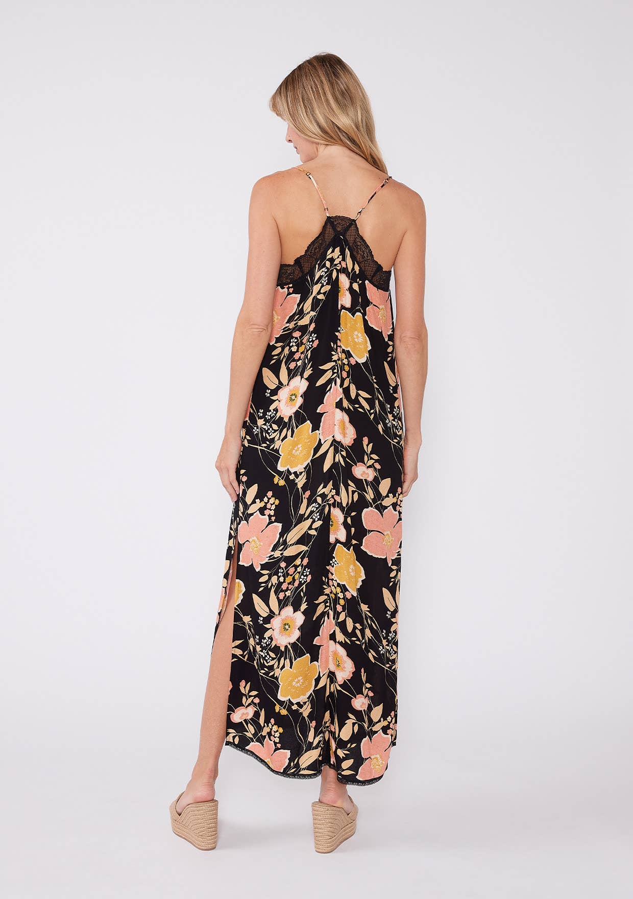 Back view of a woman wearing a Floral Lace Trim Racerback Maxi Dress with black lace and floral print design.
