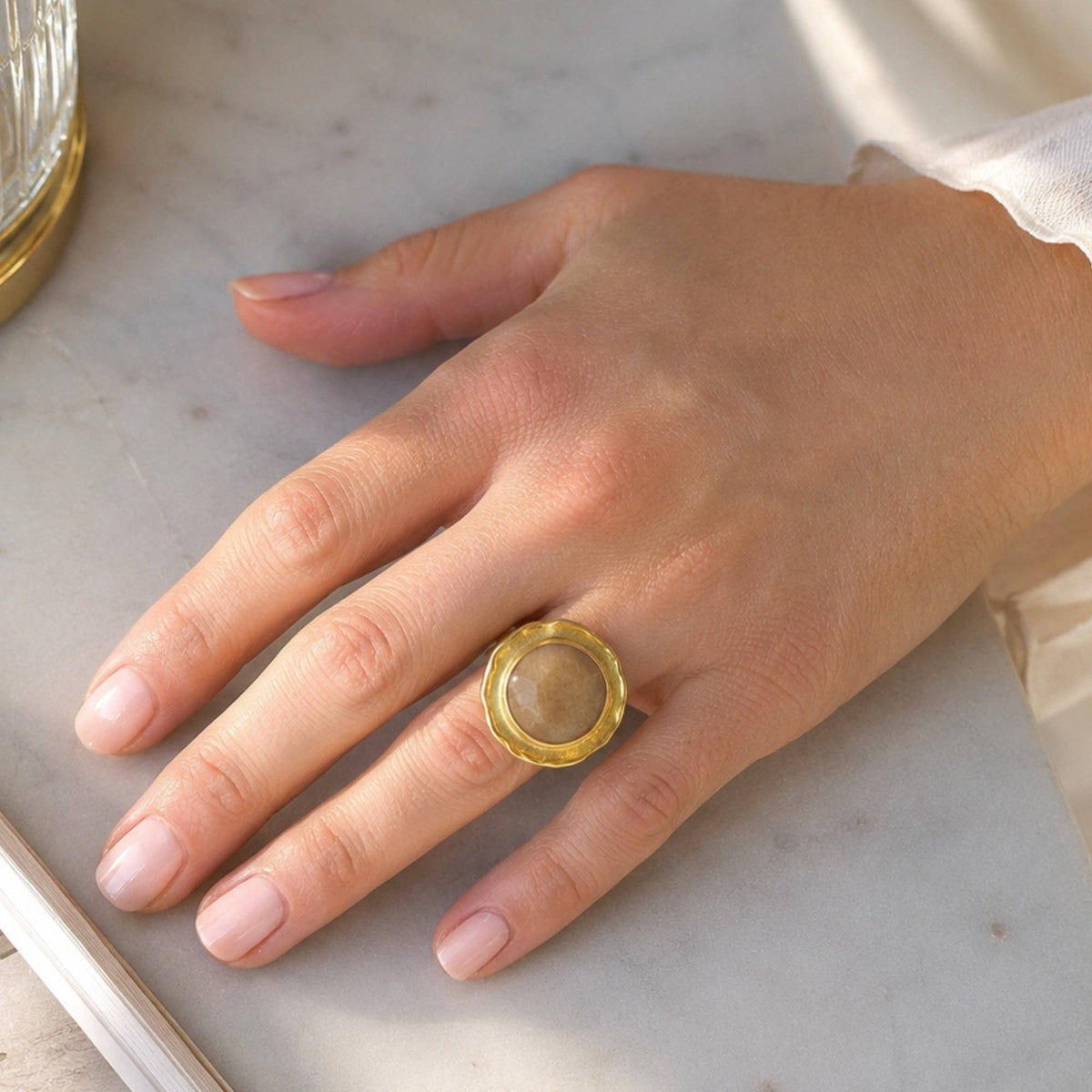 Orange Quartz Cocktail Ring - Mercan with a gold setting worn on a hand
