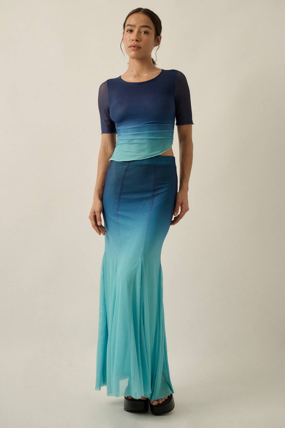 Woman wearing Ombre Mesh Fit-and-Flare Godet Maxi Skirt in blue to teal gradient with matching mesh top