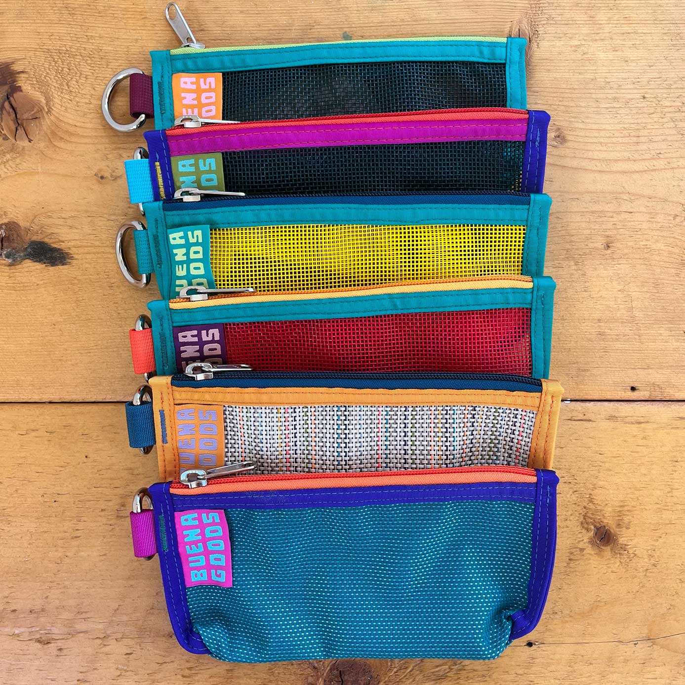 The Catch Pouch in vibrant colors with mesh panels and zipper closures, perfect for organized everyday use
