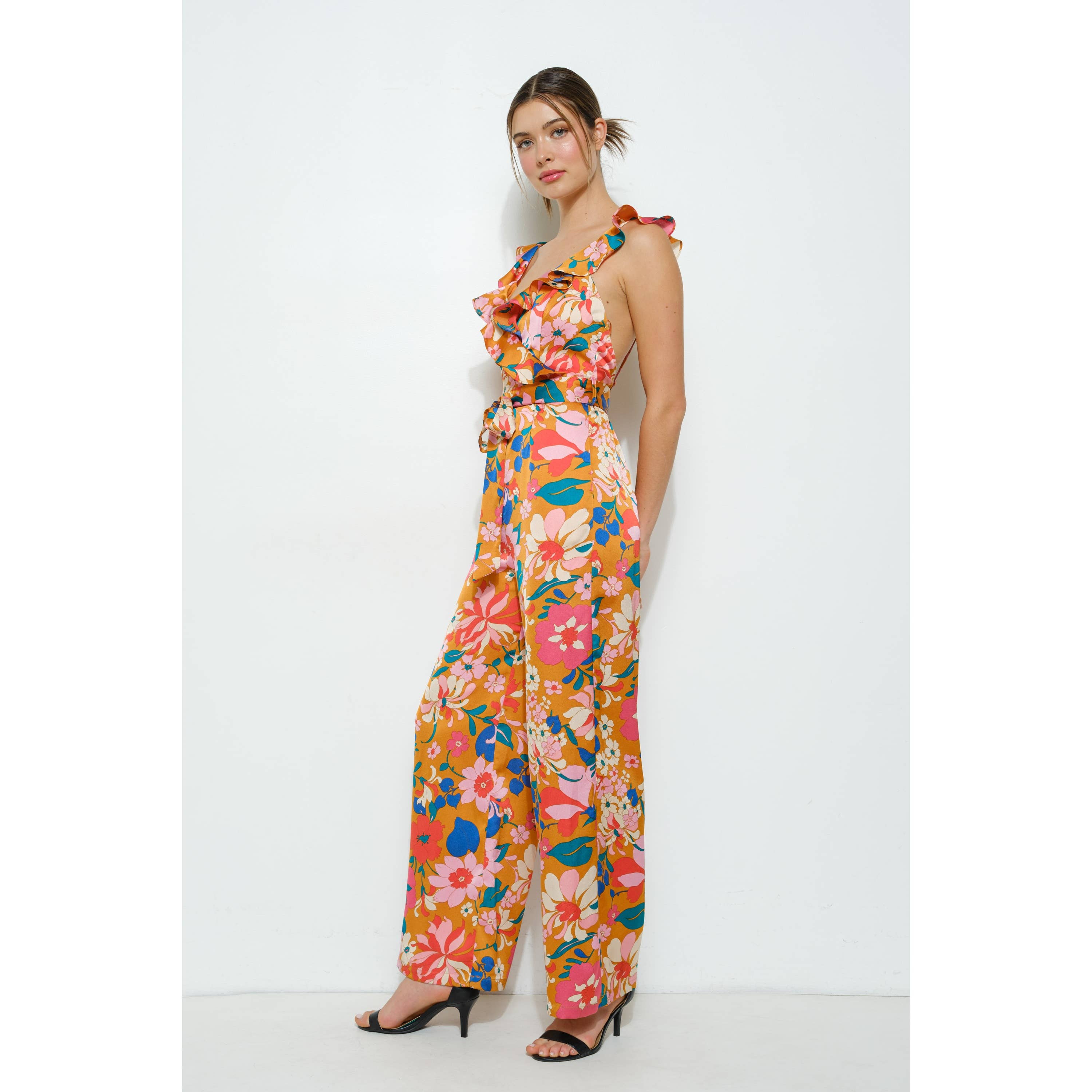 Woman wearing a colorful floral jumpsuit on a white background