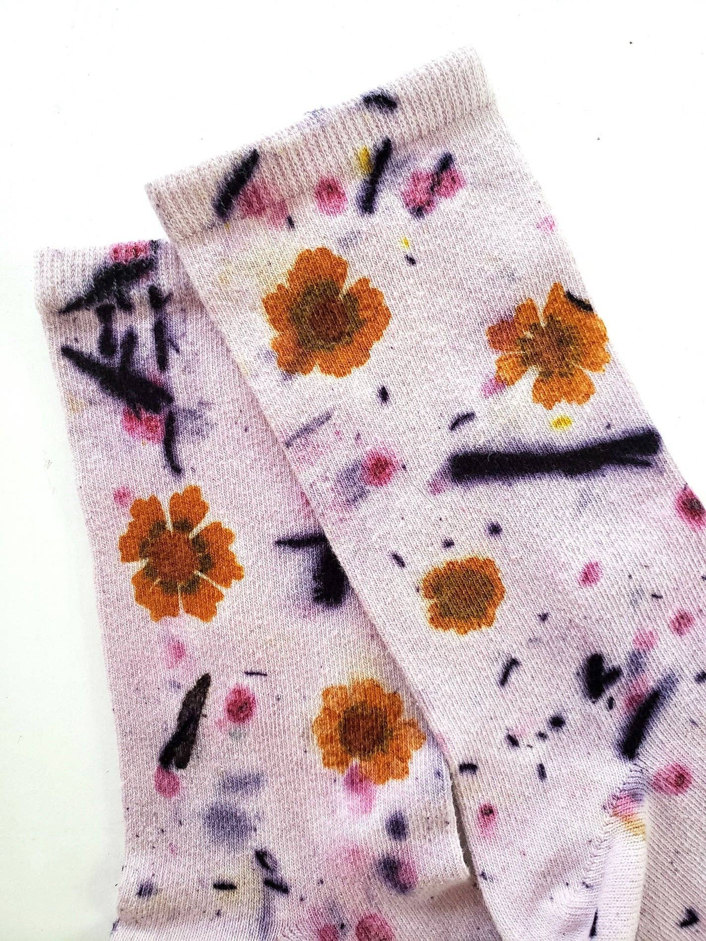 Pair of Flower Power Cotton Crew Sock with orange flower prints and abstract black accents on soft fabric