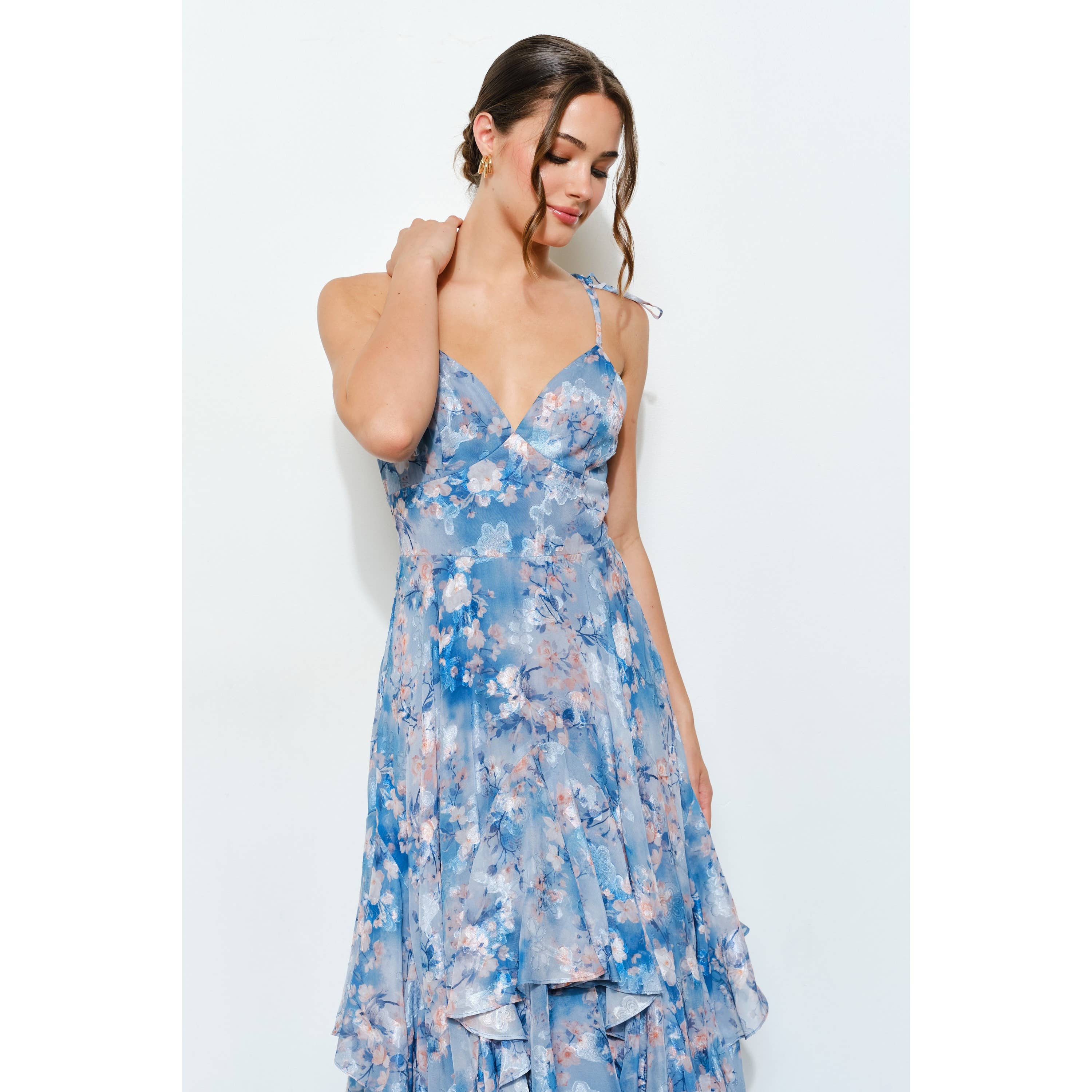 Woman wearing a blue floral Romantic Floral Sweetheart Ruffled Maxi Dress with delicate straps and ruffled layers